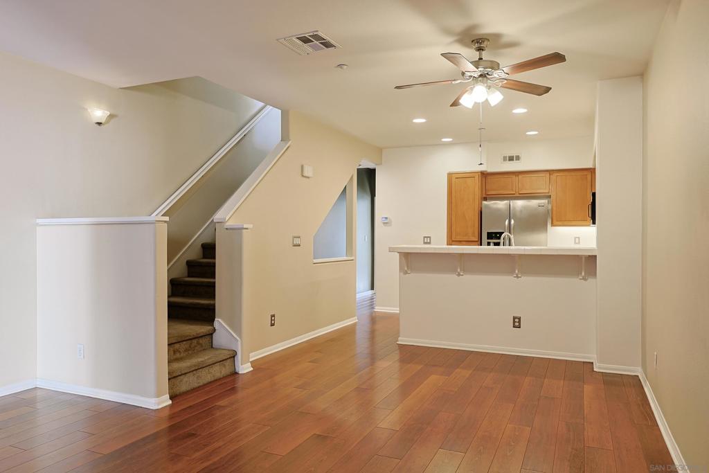 Welcome to the coveted Legacy Walk community, where comfort meets convenience in this spacious, updated unit with attached garage. Step inside to an inviting open-concept living area with warm LVT flooring and a sliding door leading to a generous private patio – perfect for morning coffee, evening gatherings, or simply enjoying San Diego’s year-round sunshine. The dining area opens to a freshly painted kitchen featuring tile countertops, recessed lighting, and updated stainless steel appliances, faucet, and garbage disposal. This home offers flexibility with a full bedroom and bathroom on the main floor, plus a laundry closet with a stacked washer and dryer for easy living. Upstairs, retreat to the spacious primary suite adorned with charming wainscoting and an ensuite bathroom with sleek tile flooring. An additional upstairs bedroom, also freshly painted, features its own attached bathroom. An attached two-car tandem garage offers convenience and extra storage, while the well-maintained Legacy Walk community surrounds you with lush landscaping, dog parks, grassy areas, and a welcoming street-level outdoor patio space. Enjoy a lifestyle of ease with multiple parks, the Willie Henderson Sports Complex, shopping, and dining all within walking distance – and just minutes to the San Diego Bay, Coronado beaches, and the vibrant energy of Downtown San Diego.