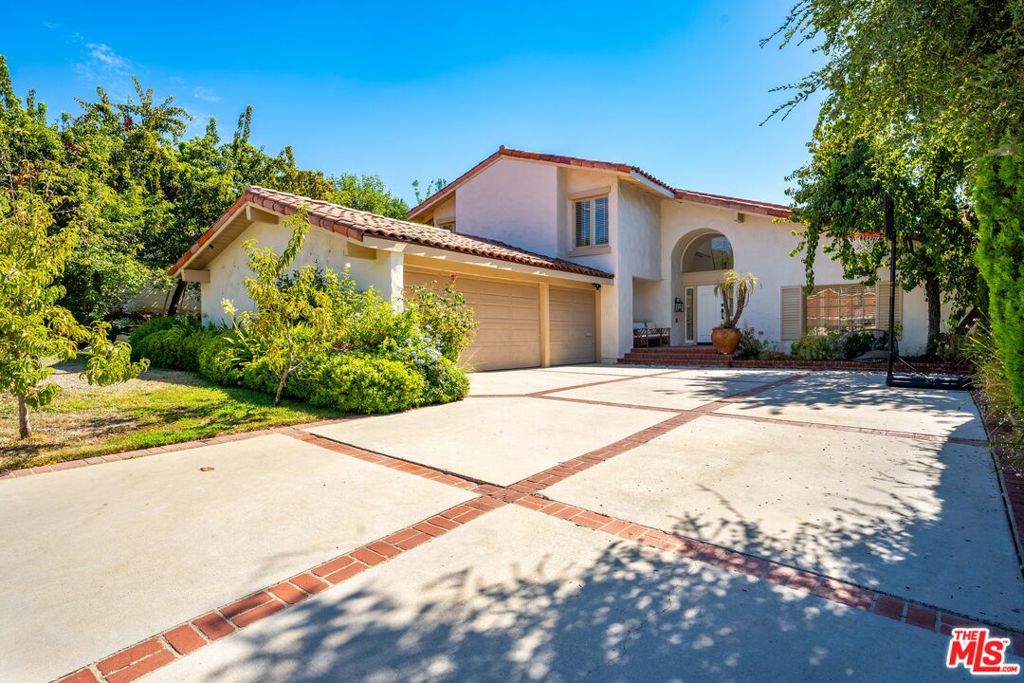 Discover your oasis in the heart of Calabasas. Nestled in this prestigious community, this newly refreshed 5-bedroom haven offers the perfect blend of luxury and natural beauty. Backing onto a lush grove of trees, this property provides a serene escape while keeping you connected to all the amenities of upscale suburban living.Step inside to find gleaming natural wood floors and plush new carpeting throughout, creating a bright, airy ambiance enhanced by soft white walls and multiple large skylights. The thoughtful floor plan features 4 bedrooms upstairs, 1 bedroom and bath downstairs, plus a powder room. At the heart of the home, the gourmet kitchen showcases sleek white Caesarstone countertops, pristine cabinetry, high-end stainless steel appliances, and a built-in Sub-Zero refrigerator. Retreat to the tranquil primary suite, boasting picturesque views through expansive windows, abundant natural light, dual closets, and a separate vanity area. Spacious secondary bedrooms, a convenient indoor laundry room, and an attached 3-car garage complete the interior.Comfort and efficiency are assured with double-paned windows and an updated dual-zone heating and A/C system. Step outside to your own resort-style paradise, featuring an inviting salt-water pool and spa, expansive entertaining areas, and a lush tree-lined backdrop creating a private retreat. An indulgent outdoor shower adds a touch of luxury to your backyard oasis.This prime Calabasas location offers the best of everything: steps away from the exclusive lake and resident-only common areas, easy access to The Commons shopping center, a Saturday Farmer's Market within walking distance, and scenic paths for strolls or bike rides. Commuters will appreciate the quick freeway access, while families can take advantage of the excellent Las Virgenes school district.