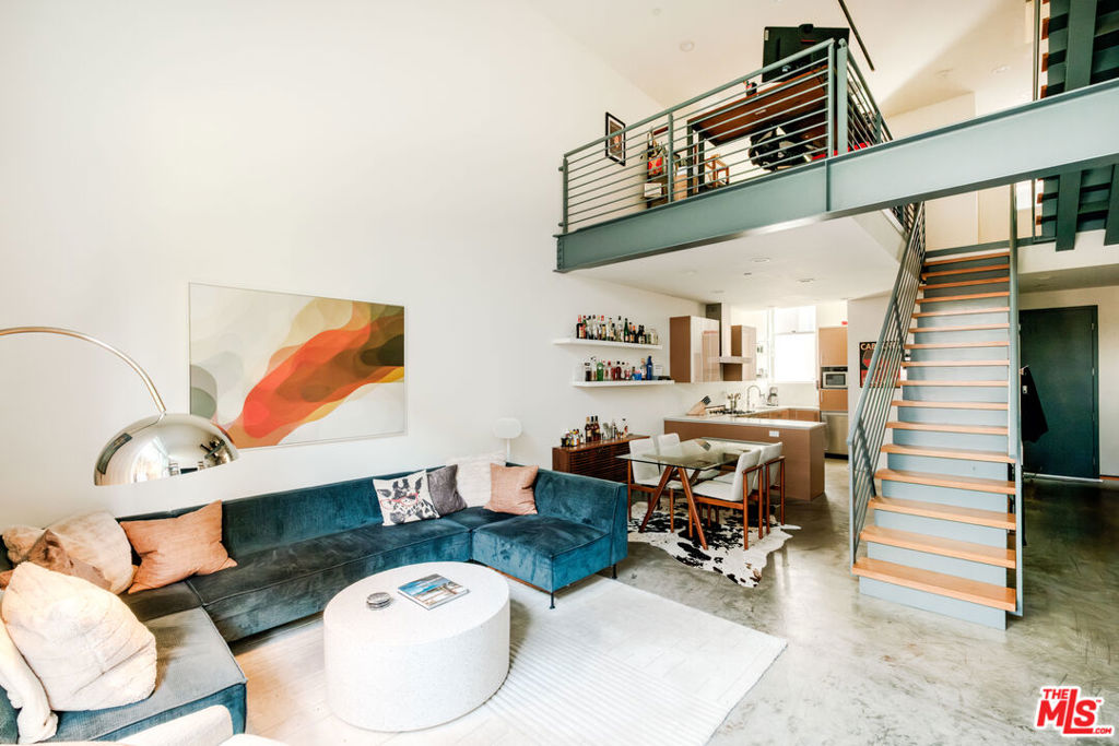 Offered Unfurnished and Available for Immediate Occupancy! Warm architectural character meets modern industrial design in this striking 2-bedroom + loft, 2.5-bath residence in the highly sought-after Art Lofts of West Hollywood. Spanning approximately 1,830 sq ft across four light-filled levels, this townhouse-style condo features soaring 20-foot ceilings, dramatic Fleetwood windows, and a seamless blend of polished concrete and hardwood flooring. The flexible floor plan includes a spacious loft ideal for a home office, creative studio, or media lounge. A sleek chef's kitchen with stainless steel appliances anchors the main living area, flowing effortlessly into open concept living and dining spaces perfect for entertaining. Enjoy seamless indoor-outdoor flow with a private balcony off the living room and a spacious rooftop patio capturing tranquil views of the surrounding hills. Additional highlights include generous closet space, in-unit laundry, and two-car tandem parking with private storage. Set within a gated 12-unit community with guest parking and an onsite spa, and located just minutes from Whole Foods, Sunset and Santa Monica Boulevards, premier gyms, restaurants, and cafes this residence offers an exceptional fusion of architectural style and urban convenience.