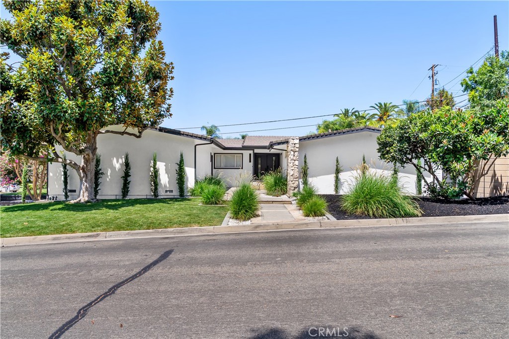 Beautifully updated single-level home on a private corner lot in the prestigious Los Coyotes Country Club neighborhood. This turn-key residence features an open floor plan with abundant natural light, sleek vinyl flooring, recessed lighting, and a striking Palos Verdes River Rock fireplace. The gourmet kitchen features a waterfall quartz island, custom European cabinetry, wine fridge, and ample storage. Offering 4 spacious bedrooms including dual primary suites, plus a flexible office/5th bedroom, this home is designed for modern living. Bathrooms showcase spa-like finishes with floating vanities, designer tile, and a soaking tub in the vaulted-ceiling primary retreat. Outdoors, enjoy newly landscaped grounds, new sprinklers, and multiple spaces for entertaining. The oversized finished garage with epoxy flooring offers room for 2 cars plus a golf cart. Additional upgrades include full plumbing re-pipe and modernized systems throughout. Just minutes from Los Coyotes Country Club, top-rated schools, shopping, dining, and freeway access, this Buena Park gem blends luxury, comfort, and convenience in one of the area’s most desirable communities.