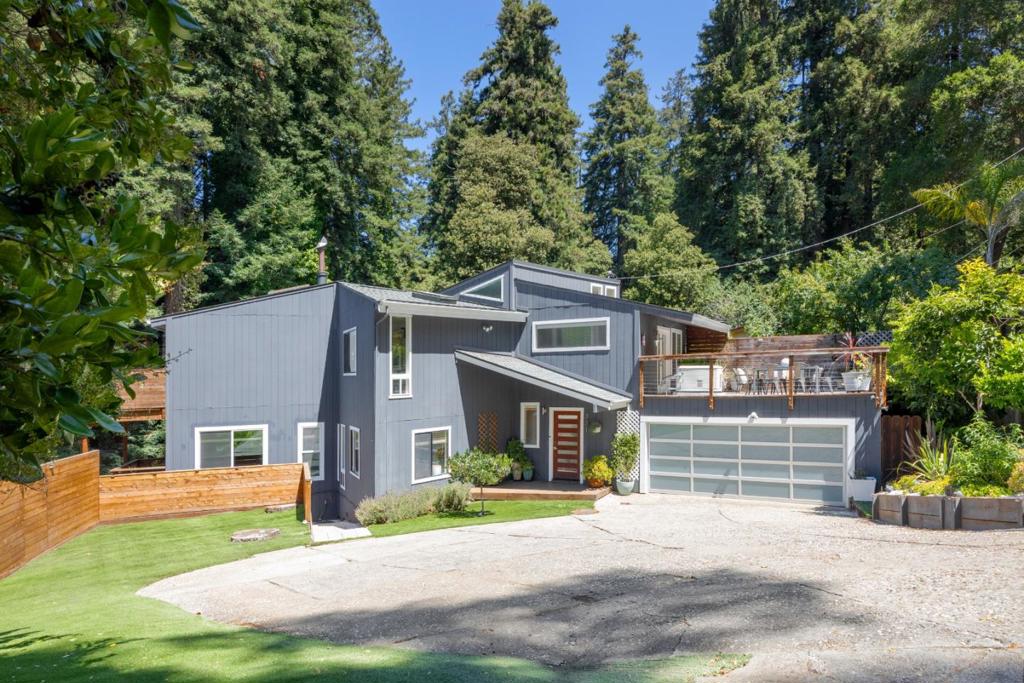 Tucked away on a private shared road with friendly neighbors less than a mile from Aptos Village, this light-filled sanctuary balances coastal style, modern upgrades, and serene redwood surroundings. The 2,412 sq ft, 4-bedroom, 2-bath reverse floorplan design maximizes natural light with vaulted ceilings, tall windows, and seamless flow between the kitchen and living spaces. French doors open to an expansive west-facing deck with an outdoor shower, perfect for entertaining or unwinding at sunset. On the main floor, three bedrooms offer peaceful privacy - two with private decks. The spacious primary suite features a private balcony retreat surrounded by trees. A bonus upstairs room with its own deck offers flexibility as an office or guest space. Artistic upgrades and smart-home features abound: Central Heat/AC, Generac 22KW back-up generator, a new roof, BidetMate heated toilet, and the following smart-equipped devices: Nest systems, motorized shades, Kasa lighting, MinkaAire fans, KitchenAid gas range, Moen touchless faucet, LiftMaster/MyQ garage opener, BHyve irrigation. Just minutes to beaches, Cabrillo College, Nisene Marks Park, shopping, dining, and top schools, this property is a rare blend of privacy, convenience, and modern comfort.