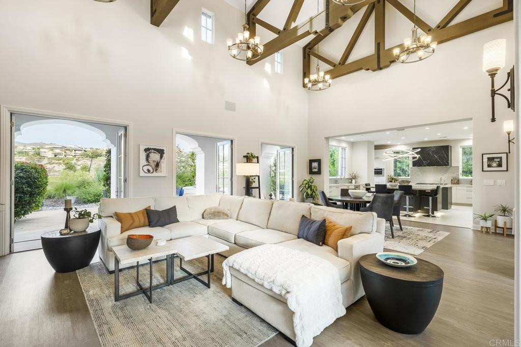 Indulge in luxury living in one of San Diego’s most sought-after gated communities. Welcome to The Lakes above Rancho Santa Fe, where this 4,774 sq. ft. home sits on nearly one acre of serene canyon-view property. A large, gated courtyard entry sets the tone as you come through the main door. This quiet oasis features lush landscaping and creates an inviting seating area to enjoy cool San Diego evenings. Upon entry, the home showcases 22-foot ceilings that establish an impressive and welcoming ambiance in the living room. This serves as the heart of the home, featuring a fireplace, generous entertaining space, and seamless views out to the backyard. Just off this room, the stunning remodeled chef’s kitchen is a true showpiece. Dual islands, Sub-Zero and Wolf appliances, modern white cabinetry, and a beautiful, temperature-controlled 288-bottle wine room create a striking focal point next to the elegant dining area, making gatherings effortless. The thoughtfully designed floor plan showcases 4 spacious bedrooms, each with en suite baths on the main floor as well as a dedicated office space. The large primary suite is a peaceful retreat with a stone fireplace, soaring views out past the canyon, a walk-in closet with built-ins, and a newly remodeled, spa-inspired bathroom with dual vanities, soaking tub, and modern walk-in shower. A dedicated office with glass doors and built-in cabinetry adds to the home’s versatility. Above the courtyard, a separate entrance leads to a second story living space featuring a large open room, a half bath and walk-in closet. This space is ideal for a home office, gym, game room, or with the simple addition of a shower, the foundation for a fantastic in-law suite. The backyard is a true oasis, meticulously crafted for both entertainment and relaxation. A lush garden creates a serene atmosphere where coastal breezes flow through the trees, while a cozy fire pit offers warmth and ambiance during cool evenings. At the heart of the space, a luxurious hot tub invites you to unwind while taking in spectacular mountain views. Just steps away, a spacious sitting area provides the perfect spot for friends to gather, share stories, and enjoy the breathtaking backdrop. Every corner of this yard showcases unobstructed vistas, making it an unparalleled retreat. Additional highlights include owned solar ensuring energy efficiency, an attached 4-car garage with epoxy flooring and abundant storage space, a whole-house water softener, and a tankless water heater. The Lakes community offers family-friendly living and is located within the highly rated, award-winning Poway Unified School District. The Crosby Club at Rancho Santa Fe is just down the street and acts as the social hub of the community where you can enjoy world-class golf, dining & entertainment, and fitness facilities with pool, tennis, and pickleball. The home is conveniently located just 12 minutes from the Village in Rancho Santa Fe and a short drive to Del Mar and Solana Beach, providing easy access to the best of Southern California's lifestyle, including 25 golf courses, 17 parks, and 4 hiking reserves within 10 miles. With over 79 restaurants within 5 miles, the home is also conveniently located near the I-15 and CA-56 freeways.