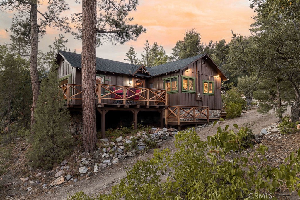 Nestled in the heart of the National Forest, this beautifully maintained 2 bedroom, 2 bathroom cabin offers the perfect blend of rustic charm and modern comfort. With over 1,000 square feet of living space, this home boasts a thoughtfully designed floorplan that feels open, functional, and inviting. Step inside to find a warm, welcoming interior highlighted by wood accents, natural textures, and a stunning native rock fireplace that serves as the centerpiece of the cozy living area. Large windows frame sweeping views of the surrounding forest, ski slopes, and the serene beauty of nature—giving you that peaceful, “cabin-in-the-woods” feeling without sacrificing convenience. Each room has been lovingly cared for, reflecting true pride of ownership throughout. The spacious kitchen and dining areas flow seamlessly, perfect for entertaining or quiet evenings at home. Two bathrooms offer comfort for guests, while the detached two-car garage provides ample storage for vehicles, tools, or outdoor gear. Whether you’re sipping your morning coffee surrounded by trees, enjoying snow-covered mountain views in winter, or simply watching wildlife pass by, this home captures the best of Big Bear’s mountain lifestyle. And while you’ll feel miles away from it all, you’re still just minutes to shopping, dining, ski resorts, and the lake. This is more than a cabin—it’s a peaceful retreat, a year-round haven, and a rare opportunity to own a forest-side gem. Don’t miss your chance to make it yours!