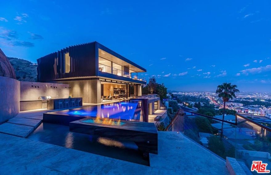 Sited privately behind a set of gates above the famed Chateau Marmont, this new modern retreat created by Roman James Design, is completed with luxe amenities and exquisite finishes. Panoramic breathtaking views from Downtown to Century City are showcased through a wall of Fleetwood glass doors. The great room features a sitting area complete with a fireplace, dining area and a gorgeous open kitchen with black absolute granite counters. The indoor flows seamlessly outside to an infinity pool, spa, two fire pits and a built-in barbecue area. Double height glass stairwell leads to the upper level where the explosive primary suite includes a private balcony and a spa-like bathroom with Antolini Panda Dalmata stone slabs. Downstairs, boasts an entertainer's dream with a game room, wine cellar, movie theater, bar, and a fitness studio with a hot and cold plunge, dry sauna and steam shower. Endless bonus features include a rooftop deck, five-car showroom in addition to the upper 2 car garage and 7+ gated off street spots. Step inside and revel in absolute splendor. Your future awaits.