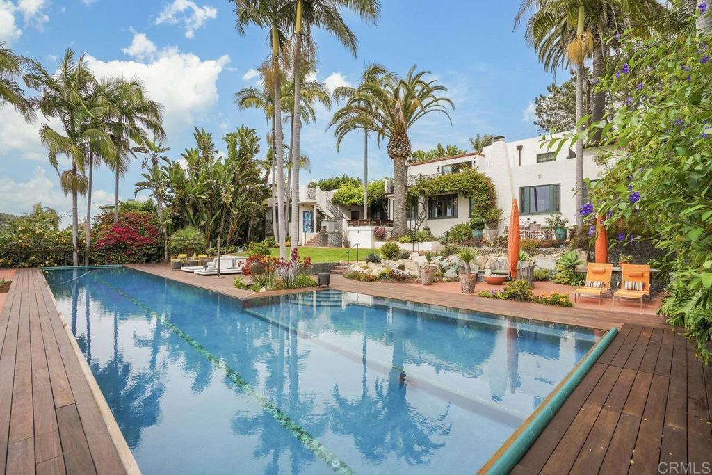 Spanish Revival Coastal Estate on 0.64 Acres with Ocean Views A rare offering in the heart of Old Encinitas/Leucadia, this Spanish Revival estate sits west of I-5 on an ultra-private, gated 0.64-acre ocean-view lot. Surrounded by lush, tropical landscaping and panoramic coastal views, the property combines architectural charm with modern functionality across three distinct structures—all rebuilt from the ground up between 2014 and 2019 with exceptional attention to detail. At the top of the property, the main residence includes a 2-bedroom, 2-bathroom home with solid red oak flooring, a chef’s kitchen outfitted with top of the line Sub-Zero, Viking, and Miele appliances, and Taj Mahal quartzite countertops. A vine-covered breezeway leads to a 1-bedroom, 1-bathroom guest suite with an office and a private rooftop deck. The adjacent garage features an African Mahogany door, workshop space, laundry, and built-in storage. Positioned at the lower end of the lot, the detached guest house (fully permitted ADU) offers 2 bedrooms, 2 bathrooms, a full kitchen, laundry, its own 2-car garage, and a separate billiards/game room—ideal for extended family, guests, or rental income. Built with Eco Red borate-treated framing, recycled denim insulation, copper plumbing, new electrical, concrete foundations, and high-end finishes, the estate also includes 52 owned solar panels and three EV charging stations. The grounds are private and serene, with mature palms, citrus, avocado, olive, and pomegranate trees surrounding a resort-style backyard. At the center is a 25-yard vanishing-edge lap pool with an automatic cover and an Ipe hardwood deck on a stainless-steel frame, flanked by a spa and two outdoor heated showers. Two gated entrances—one from Sunset Drive, the other from North Vulcan Avenue—each lead to their own garage, creating versatility and potential lot-split opportunities. A high-resolution security system, electric gates, and ample parking provide comfort, flexibility, and peace of mind. This is more than a home—it’s a rare legacy property. A true once-in-a-lifetime opportunity to own an expansive, private, ocean-view Spanish Revival-inspired estate with two access points and walkability to world-famous beaches, shops, and restaurants in the heart of Old Encinitas and Leucadia.