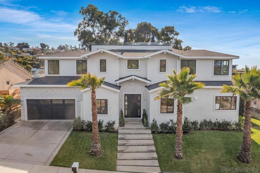 From its oversized homesite in La Jolla’s coveted Muirlands West enclave, this brand-new custom estate welcomes mesmerizing ocean, golf course, city-light, hill and canyon views. Completed in 2022 by La Jolla- based Archbel Builders, the magnificent residence overlooks the lush fairways of the La Jolla Country Club’s golf course. Curb appeal is impressive, with handsome Modern Farmhouse-inspired architecture complemented by fresh landscaping. Bright and open, the main-floor of the residence is centered around a great room, dining room and kitchen that open to the outdoors and feature wood flooring, a dramatic black marble fireplace with room-width floating wood hearth, a tray ceiling, and herringbone-patterned wood in the foyer. An  oversized island anchors a chef-caliber kitchen that showcases marble countertops, white cabinetry, open shelving, a butler’s pantry, farmhouse sink, and high-end appliances including a range with pot filler and a built-in refrigerator. Approximately 5,966 square feet, the residence features five ensuite bedrooms and six- and one-half baths that ensure comfort for everyone and include a secondary main suite on the first floor that opens to the backyard’s generously sized covered patio.  An expansive bonus  room with patio awaits on the basement level, and additional bedrooms are featured on the second floor. A large family room on the second level opens to a sunny deck, and the primary suite hosts views, a freestanding tub, a separate shower and a walk-in closet. For the ultimate in entertaining, head to the rooftop deck, where panoramic ocean  and city views are on display. Grounds extend about 15,800 square feet. Muirlands West is moments from La Jolla’s Cove and beaches, village shops and restaurants, Torrey Pines, downtown San Diego, top schools, a farmers market, and San Diego International Airport.