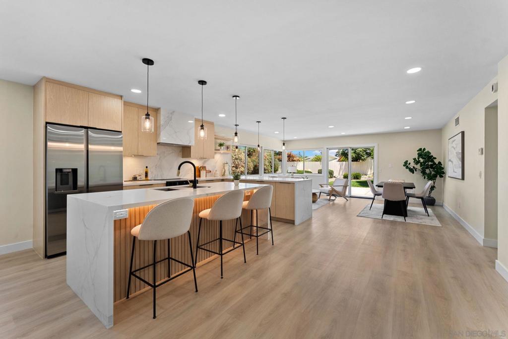 Welcome to this beautifully reimagined 5-bedroom, 3-bath residence—where designer detail and California comfort come together in perfect harmony. Step inside to a bright, open-concept living space that immediately impresses. At the heart of the home is a showstopping chef’s kitchen, complete with white oak cabinetry, waterfall-edge quartz countertops, and a stunning statement backsplash. A full suite of premium stainless-steel appliances and an oversized island with pendant lighting make it the ideal space for cooking, gathering, and entertaining. The kitchen flows seamlessly into the dining and living areas, framed by expansive glass sliders that open to a lushly landscaped backyard—creating the ultimate indoor-outdoor connection. Wide-plank luxury vinyl flooring runs throughout, adding warmth and sophistication to the modern design palette. Every bathroom in the home has been fully transformed with designer tilework, floating vanities, and contemporary fixtures that elevate everyday living. With five bedrooms, there’s space for family, guests, or a dedicated home office. Set on a peaceful street in one of Rancho Bernardo’s most desirable neighborhoods, this turnkey home offers convenience to award-winning schools, shopping, dining, golf courses, and parks. Stylish. Spacious. Move-in ready. This is the modern Rancho Bernardo lifestyle at its best.