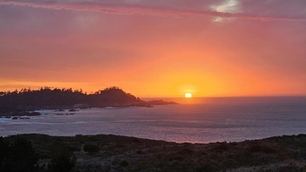 Exceptional Panoramic Ocean Views. Step into this stunning Carmel home and be immediately captivated by unobstructed views of the Pacific Ocean, Point Lobos, and the Carmelite Monastery. Designed by acclaimed architect Gene Takigawa, this residence offers breathtaking vistas from nearly every room. The main-level primary suite offers the luxury of waking up to sweeping ocean views. Enjoy your morning coffee in the cozy kitchen sitting area, where the coastline sets the tone for the day. A refined study provides an inspiring workspace also framed by the remarkable views. The living room features soaring ceilings, exceptional views, a welcoming fireplace, and a dining area with a convenient pass-through to the kitchen. A guest bedroom and full bath complete the main floor. On the lower level, a guest suite offers its own living room, kitchen, bedroom, and fireplace with the same panoramic views. A greenbelt ensures protection of the views, preserving the natural beauty that defines this home. Just a short stroll to beach access and hiking at the far end of the street, and minutes to downtown Carmel and the Crossroads shopping area, the location is as ideal as the setting. Equipped with a security system.