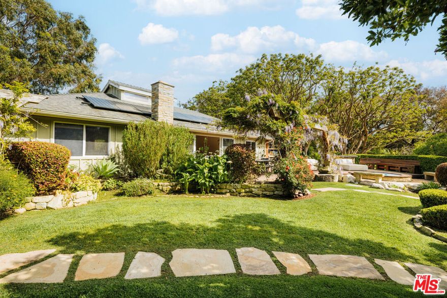 Beyond a gated entry, this sprawling coastal compound unfolds with unexpected charm, privacy, and unforgettable design. A covered front entrance with a glass door welcomes you into the main residence, immediately setting the tone for laid-back luxury. To the left, the kitchen features stone tile floors and soaring wood-beamed ceilings with recessed lighting. Deep green stone counters and warm wood cabinetry create a rich, organic feel, paired with top-of-the-line appliances including a Wolf six-burner range with hood, Miele dishwasher, Sub-Zero see-through fridge with freezer drawers, and a central island with bar seating perfect for casual gatherings and elevated cooking alike. Open to the main living space, the home transitions into a great room filled with natural light from a central skylight. Wood floors and wood-clad vaulted ceilings add warmth, while the stone fireplace serves as a beautiful focal point. A built-in speaker system and sliding glass doors that lead to the backyard complete the seamless indoor-outdoor experience. The adjacent dining area offers a comfortable place to entertain, with views out to the gardens. Off the main living area are several bedrooms, each offering privacy, light, and character. The first bedroom features wood floors, sliding mirrored closet doors, and access to the backyard through glass doors. A hallway bathroom nearby includes a skylight, shower over tub, stone counters, vanity, and built-ins. The primary suite offers wood floors, French doors to a private patio, and a large closet with custom built-ins. Its en-suite bath is finished with stone counters, double sinks, a skylight, and a large shower. Another bedroom off the front entry offers wood floors, sliding doors to the backyard, an en-suite bath with walk-in shower, and a private entrance to the garage.The two-car garage includes two sets of washers and dryers, a secondary fridge, sink, and extensive built-in storage. Outside, the backyard becomes a private retreat with a wood deck strung with lights, multiple dining and lounging areas, and an in-ground Jacuzzi surrounded by built-in seating. The outdoor kitchen area features a Lynx BBQ, sink, counters with bar seating, and a mini fridge. An additional surfboard storage area, grassy lawn, koi pond with waterfall feature, and multiple outdoor showers make this property feel like your own private resort just steps from the beach path. The second main residence, set privately on the property, offers its own complete home with wood floors, sliding glass doors, and a full kitchen equipped with butcher block and stone counters, a Whirlpool dishwasher, Viking hood fan, trash compactor, double oven with broiler, and Sub-Zero fridge. An adjacent living area and deck offer relaxing views and outdoor dining space. Upstairs, a vaulted wood-beam bedroom is paired with a spacious bath featuring a double vanity, shower stall, and linen storage. Across from this home sits a surf shack and additional outdoor showers for easy beach living. Elsewhere on the property are three unique tiny homes, each with its own function and charm. The first features wood floors, skylights, a mudroom, a private shower and vanity, and a nearby sauna nestled off a stone path. The second offers a kitchenette, mini fridge, bar seating, a powder room, and an outdoor shower. The third tiny home, attached below the second main house, includes a bedroom with sliding glass doors, mini kitchen, built-ins, an en-suite bath with shower and bidet, and a private deck with a mini fireplace. Adding to the resort-like experience are a dedicated yoga and meditation pavilion, a tiki hut with surfboard storage, and a playful area with BB gun targets. With its rare blend of casual elegance, functional flexibility, and proximity to the beach, this one-of-a-kind property captures the essence of laid-back California luxury.