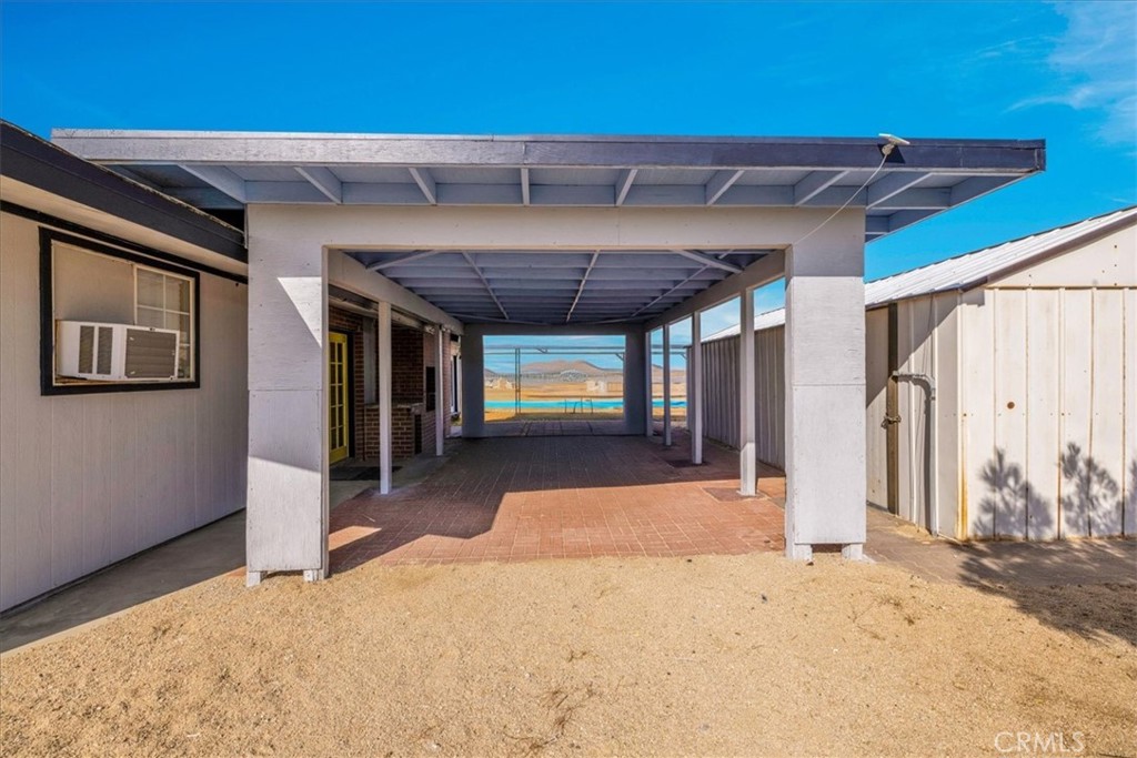 Escape to your own private desert retreat with this charming 2-bedroom, 1-bath home tucked away on 5 scenic, fully fenced acres. Thoughtfully updated and full of character, the heart of the home is a beautifully remodeled kitchen featuring granite countertops, stainless steel appliances, a prep sink in the island, and a walk-in pantry. Large windows frame stunning eastern views, welcoming in breathtaking sunrises each morning. The updated bathroom includes a sleek walk-in shower, while the cozy fireplace with insert adds warmth and ambiance on cooler nights. Wood-look laminate flooring flows throughout, and the entire home has been freshly painted inside and out. A spacious carport and shed offer protection for your vehicles, and a generous greenhouse plus an additional outbuilding make ideal spaces for hobbies or an art studio. Full RV hookups, including 50-amp electrical service, septic, and water, add convenience and flexibility for your out of town guests.. Just minutes from local favorites like La Copine, Pappy & Harriet’s, Giant Rock, and Joshua Tree National Park, this peaceful haven offers expansive views in every direction.