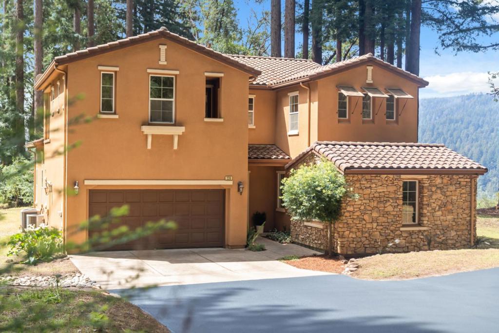 Welcome to 220 Hillary Heights, a peaceful retreat perched on a quiet ridgetop in the Santa Cruz Mountains. Built in 2007, this spacious 4-bedroom, 4-bathroom home is set on over 1.5 acres of mostly flat, sunny land, offering sweeping views of the San Lorenzo Valley. Fresh interior paint and newly installed carpet create a move-in-ready feel throughout. The open-concept main level invites effortless living and entertaining, featuring a well-appointed kitchen with abundant counter space, an oversized island with bar seating, and a seamless connection to the inviting living room with a fireplace, perfect for cozy evenings. A flex space on the main floor provides the ideal space for a home office, creative studio, or guest lounge. Upstairs, the expansive primary suite offers a true retreat, complete with an oversized closet and a spa-inspired ensuite bathroom with a jetted soaking tub. Venture outside and enjoy the natural beauty and privacy of your generous lot, ideal for gardening, play, or relaxing under the open sky. An attached two-car garage offers plenty of room for parking and storage. Experience comfort, space, and scenic living at 220 Hillary Heights.