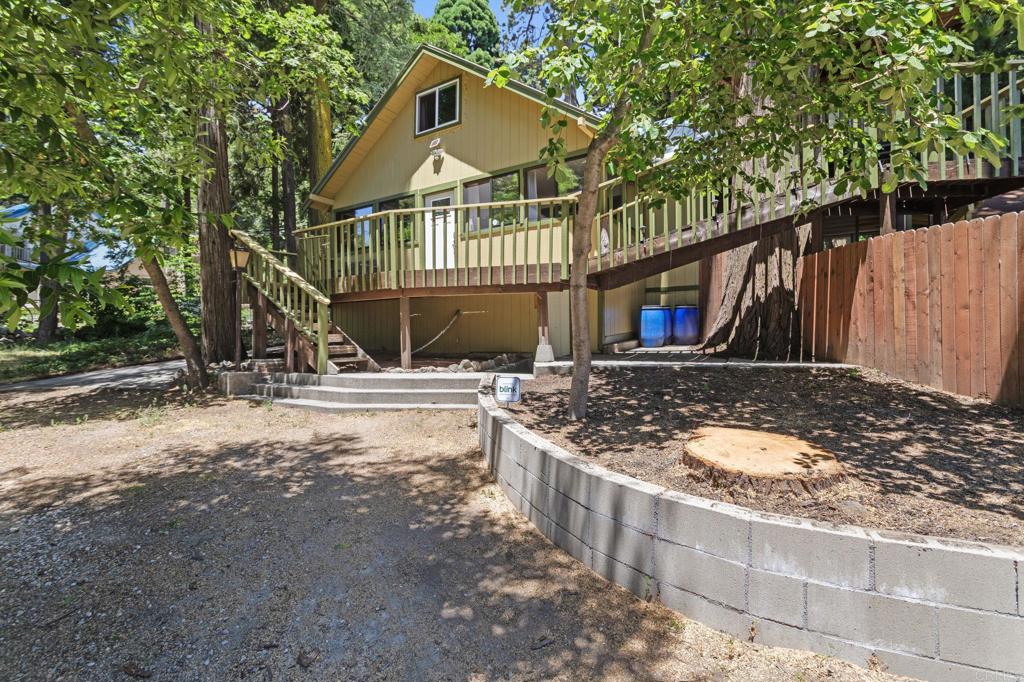 Welcome to your one-of-a-kind mountain home perfect for primary residence, vacation getaway, or Airbnb investment. Experience the Power of Mountain Living at 1148 Saturn, Crestline. Discover a rare opportunity to live in harmony with nature featuring a flat half acre lot fully usable and perfectly curated for a lifestyle of freedom, beauty, and functionality. Nestled among towering pines, this stunning mountain retreat offers a seamless blend of cabin charm and comfort. As you arrive, the expansive circular driveway welcomes you with ample space for guests, RVs, and boats an outdoor enthusiast’s dream. The charming variety of fruit trees and plants, including 2 apple trees, 3 pear trees, 2 cherry trees, 1 mulberry, wild strawberries, 2 peach trees, and 1 plum tree plus a mind and rosemary plant for refresh, aromatic herbs right at home. Step into your retreat through one of three main entrances and be instantly captivated by the exposed 100-year-old beams, soaring ceilings, and a striking rock fireplace with a brand-new insert a centerpiece of warmth and style. The open concept kitchen features granite countertops, stainless steel appliances, and natural flow into the living space, creating the ideal setting for both everyday living and entertaining. A rare ground-level bedroom and full bath add flexibility, along with a bonus enclosed room perfect for a home office, workshop, or additional storage. Upstairs, transform the oversized suite into your personal master retreat or divide into two generous bedrooms the possibilities are endless. Step outside to the wrap-around deck and breathe in the crisp mountain air as you overlook your expansive sanctuary, complete with a hardscaped patio, garden beds, chicken coop, wood storage, and a lush grass area that rivals suburban backyards below the hill. This is more than a home it’s a lifestyle powered by nature, peace, and possibility.