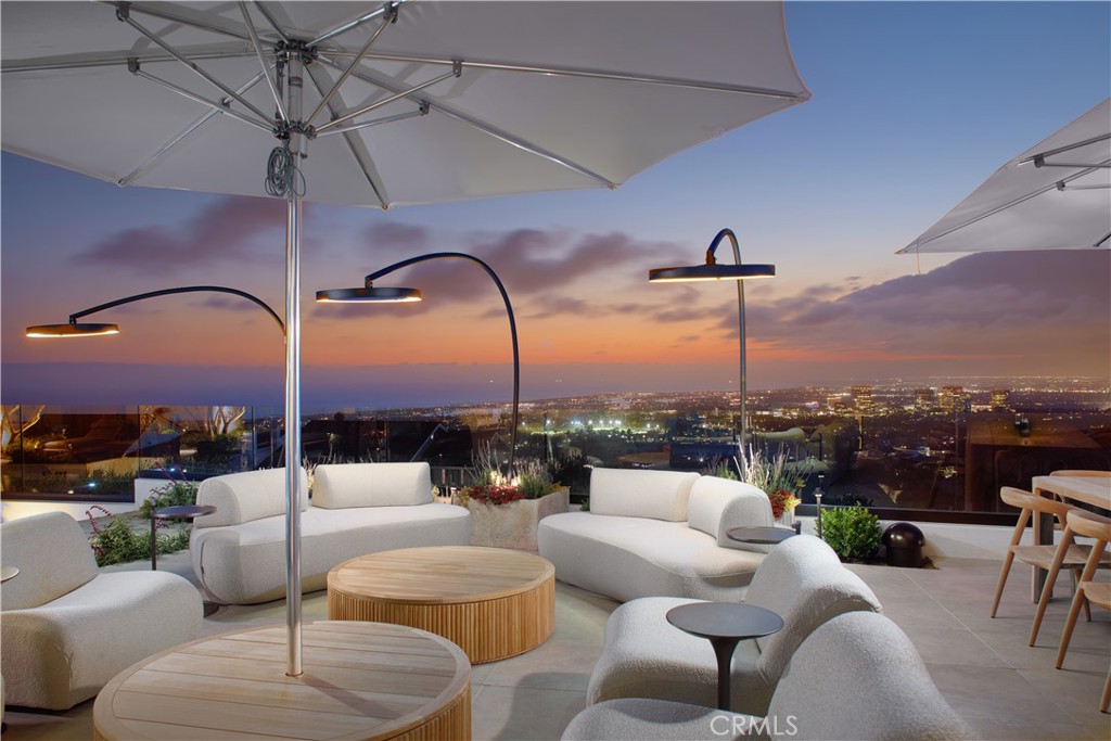 Perched atop Spyglass Hill with sweeping views of the Pacific, Catalina Island, Newport Harbor, and glittering city lights, this newly reimagined coastal estate offers rare serenity just minutes from Fashion Island and Corona del Mar Village. Marrying warm contemporary design with refined craftsmanship, the home embodies the best of elevated Southern California living. Beyond a stately teak-gated entrance, a cobblestone drive winds through manicured gardens to reveal a striking façade of smooth plaster and expansive picture windows—a prelude to the exquisite interiors. At the center, an open-air Mediterranean-modern courtyard invites starlit gatherings around a sculptural fire feature, seamlessly blurring the line between indoor and outdoor living. Designed for both grand entertaining and intimate living, the estate features two fully equipped kitchens. The primary chef’s kitchen includes a 72” AGA Induction range, Sub-Zero glass-panel refrigeration, Miele espresso system, dual dishwashers, and Wolf microwave. Calacatta Terrazzo, Naval Brass, rift white oak cabinetry, and Dorn Bracht fixtures elevate every detail. The adjoining catering kitchen adds a 48” Viking Pro gas range, under-counter refrigeration, warming drawers, and passthrough service for effortless hosting. The open-concept great room connects dining, living, and outdoor spaces with a Bang & Olufsen sound system and floor-to-ceiling glass that opens to a sun-drenched terrace. Outside, enjoy a heated pool and spa, curated gardens, al fresco dining, and lounge areas with unforgettable views. Private quarters are equally refined. Two primary suites offer panoramic ocean-to-mountain vistas, spa-caliber baths finished in Pink Cristallo quartzite, Fantini fixtures, in-suite laundry, walk-in closets, and LG clothing steamers. Two additional guest suites provide quiet luxury and comfort. An executive office with custom built-ins anchors the main level, while a second office-library in the primary wing opens to fresh air and natural light. A hidden media experience, wet bar, two powder rooms, and a beautifully appointed laundry room with pet wash enhance day-to-day living. Throughout the home, handcrafted Moroccan Zellige tile adds texture and quiet sophistication. A hidden speakeasy—discreet and inviting—offers the perfect setting for rare spirits and private evenings. This is not merely a remodel, but a masterful reinvention—crafted for those who value design, distinction, and the art of living well.