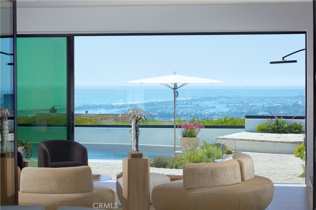 Extensively rebuilt and reimagined in 2025, this 7,087± sqft estate in Corona del Mar’s exclusive Spyglass community blends timeless architecture with panoramic ocean, harbor, city, and mountain views. Set on a rare oversized lot, 17 Muir Beach offers unmatched privacy and refined coastal living. The home boasts four luxurious en-suite bedrooms, dual offices, three gorgeous powder rooms, rift white oak cabinetry and a catering kitchen with a full set of Viking appliances. A second (attached but separate) chef’s kitchen featuring dual AGA ranges, Wolf, Sub-Zero and Miele appliances with custom countertops made of naval brass and Calacatta Terrazzo finish the bespoke design. Five fireplaces, three wet bars, and smart home integration add to the elevated lifestyle. The luxuries of the home are matched only by the conveniences and range from genuine granite cobblestone and hand crafted Moroccan Zellige tiles to a built-in dog wash and full-size clothing steamer. An impressive subterranean level reveals a hidden speak-easy lounge with a custom brass bar, 1,000 bottle temp controlled wine cellar and powder bath - offering a one of a kind entertaining experience. Outdoors, the resort style grounds are complete with a newly rebuilt pool and spa, four tranquil fountains, teak garage doors/gates and professional landscaping - all enhanced by expert lighting and commercial outdoor heaters for year-round comfort. Just minutes from Fashion Island, CDM Village, beaches, and top-rated schools, this extraordinary estate defines modern coastal luxury.
