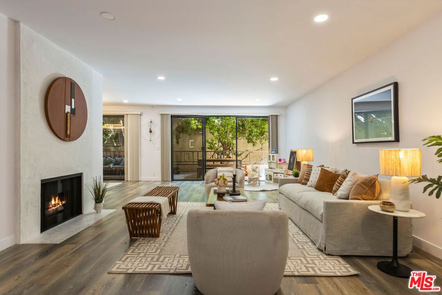 Experience a rare true gem in prime West Hollywood is 1210 N Kings Rd unit 101. A designer-crafted 2,500 sq ft showplace with an incredible oversized approximately 433 sq ft outdoor terrace. Every detail of this residence has been thoughtfully curated for style, comfort, and functionality. Flooded with natural light, the indoor outdoor open-concept layout flows effortlessly perfect for gatherings or evening entertaining. Warm tone floors, and designer-selected fixtures create a sophisticated vibe throughout. The living room features a sleek gas fireplace, a built-in wet bar, and expansive sliders that blur the line between indoor and outdoor living. The adjacent gourmet kitchen boasts custom cabinetry, premium stainless steel appliances, and ample counter space for a home chef. The primary suite is a serene retreat with a generous separate his and hers walk-in closet. Enjoy a spa-inspired ensuite bathroom complete with an oversized tub and glass-enclosed shower. Thoughtfully positioned within the building for maximum privacy, this unit offers two dedicated parking spaces. You're just steps from shopping, a diverse array of eatery, vibrant nightlife, and much more.