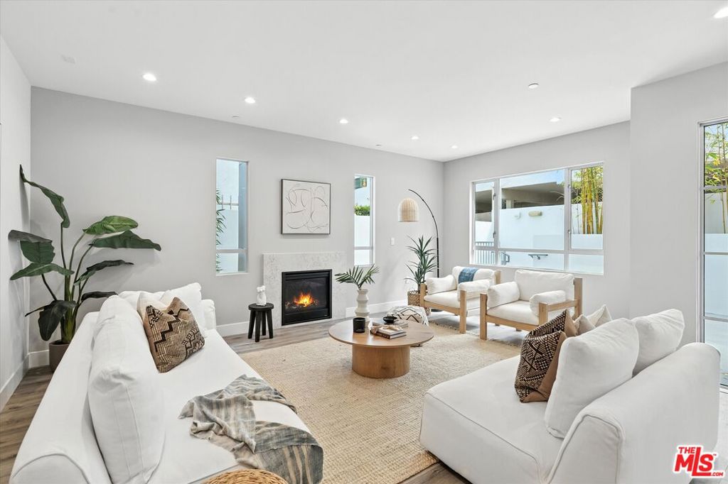 Welcome to your new sanctuary in West Los Angeles on the border of Santa Monica. With 1,721 square feet, this 3-bedroom, 2.5-bathroom condo offers a harmonious blend of modern design and comfort. Step inside to find spacious living areas adorned with sleek vinyl floors and illuminated by ambient recessed lighting, creating a warm and inviting atmosphere. The living room features a tasteful decorative fireplace, perfect for cozy evenings. The primary ensuite bathroom stands out with its luxurious separate shower, offering a private oasis for relaxation. Each bedroom is designed to provide ample space and comfort, ensuring restful nights. The gourmet kitchen features a breakfast bar, custom quartz countertops, sleek cabinetry, and top-of-the-line Fisher Paykel stainless steel appliances, all set against elegant ceramic tile flooring. Outdoor living is a joy with a private patio to enjoy morning coffee or evening breezes. Additionally, the building provides access to a common roof deck for panoramic views and a communal patio for social gatherings. Convenience is enhanced by having a washer and dryer in the unit, while parking needs are met with 2 assigned spaces in the gated, secure garage. The parking spaces are conveniently wired for EV charging. For peace of mind, the building features an electric gate and intercom system, providing an added layer of security. Nestled near Sawtelle, Brentwood, and adjacent to Santa Monica, this home offers easy access to premier dining, shopping, entertainment, farmers market, and the Expo Line, connecting you to all the vibrant offerings of the Westside. This is contemporary Westside living at its finest! Guest parking is available for all open houses and showings.