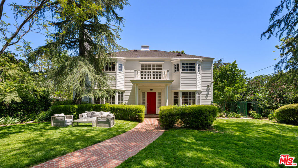 A rare entertainer's paradise in the heart of Tarzana. This gated 4500+sf Classic Georgian sits on an almost 1/2 acre FLAT lot S. of the boulevard offering both privacy and so much space that it's sure to become THE venue for every gathering. Step through the red front door into the grand foyer and immediately you'll notice the 10'ft ceilings throughout, meander through the formal living and dining rooms to the spacious family room leading to the covered porch, ideal for SoCal's indoor-outdoor lifestyle and casual outdoor parties. The inviting chef's kitchen offers tons of cabinet space, high-end appliances and a butler's pantry. Upstairs, the primary suite is a serene retreat with a spa-like en-suite bathroom and a large terrace overlooking the incredible backyard and gleaming pool. Two additional bedrooms each have en-suite bathrooms, and the study/library, also with terrace access, is an ideal home office or study space. The absolute showstopper is the lush, flat, park-like backyard with its fruit trees, ranging from pomegranate, avocado, apple, walnut and 7 types of citrus, and its sparkling pool and outdoor grilling area. House guests may decide to stay a while thanks to the approx. 400sf guest house that can double as a pool cabana. A beautifully maintained rose garden and an enclosed garden area for vegetables with raised beds complete the picture. Close to great schools and just off Ventura Blvd, this property has a 3-car garage and a full attic with 8' ft ceilings. Be ready to become the favorite home for birthdays, showers and weddings. You may even get a location scout knocking on your door!