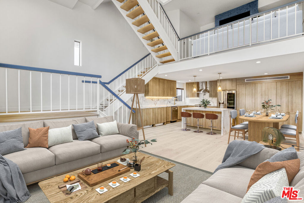 Stunningly remodeled and reimagined 2 bed (+ loft), 3 bath Single Family Home alternative townhome with Getty views in the heart of Brentwood. This 1,916 sqft corner unit was completely remodeled in 2025 with timeless design and modern sophistication. The main level features an open-concept living and dining area anchored by a large stone island, flowing into a chef's kitchen with custom oak casework cabinetry, stone counters, and high-end stainless-steel appliances. Twenty-foot, floor-to-ceiling windows and wide-plank French oak floors extend throughout, enhancing the abundant natural light and spacious feel. A versatile loft provides the perfect flex space for a home office, den, or guest retreat. The primary suite offers a marble-clad bath, generous closet space, a second fireplace, and views of the Getty Museum. Secondary bedroom and baths are equally refined, showcasing attention to detail and thoughtful design. Additional features include in-unit washer & dryer, central AC and heat, and two side-by-side gated parking spaces. Located in an intimate postmodern building with only nine residences, this townhome offers privacy and proximity to San Vicente's premier dining, boutiques, and cafes.