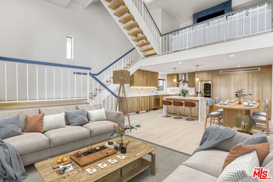 Stunningly remodeled and reimagined 2 bed (+ loft), 3 bath Single Family Home alternative townhome with Getty views in the heart of Brentwood. This 1,916 sqft corner unit was completely remodeled in 2025 with timeless design and modern sophistication. The main level features an open-concept living and dining area anchored by a large stone island, flowing into a chef's kitchen with custom oak casework cabinetry, stone counters, and high-end stainless-steel appliances. Twenty-foot, floor-to-ceiling windows and wide-plank French oak floors extend throughout, enhancing the abundant natural light and spacious feel. A versatile loft provides the perfect flex space for a home office, den, or guest retreat. The primary suite offers a marble-clad bath, generous closet space, a second fireplace, and views of the Getty Museum. Secondary bedroom and baths are equally refined, showcasing attention to detail and thoughtful design. Additional features include in-unit washer & dryer, central AC and heat, and two side-by-side gated parking spaces. Located in an intimate postmodern building with only nine residences, this townhome offers privacy and proximity to San Vicente's premier dining, boutiques, and cafes.