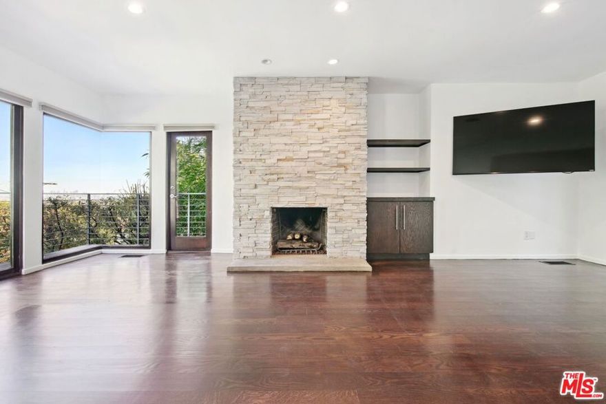 Nestled in an exceptional location just above the iconic Chateau Marmont and the vibrant Sunset Strip, this stunning 3-bedroom, 4-bathroom architectural retreat effortlessly combines elegance, comfort, and spectacular city views. Designed to make the most of space and natural light, the home's open floor plan seamlessly integrates indoor and outdoor living, creating an ideal environment for both entertaining and relaxing. As you step inside, you're welcomed by a formal entrance that flows into the spacious and inviting living area. An open layout, a cozy fireplace, and striking glass walls that frame breathtaking city views from Downtown LA to Century City, make it the perfect spot to unwind or host guests. Just off the living room, the outdoor space showcases a generously sized deck surrounded by lush greenery, offering a peaceful, private sanctuary. A cascading waterfall further enhances the tranquil atmosphere, seamlessly integrating indoor and outdoor living. A comfortable family area situated between the living and dining spaces effortlessly flows into the expansive kitchen - a true haven for cooking enthusiasts. Equipped with stainless steel appliances, sleek countertops, a breakfast bar, abundant workspace, and ample storage, the kitchen is designed to inspire your inner chef! The soaring 10-foot sky-lighted ceilings fill the space with natural light, and a unique balcony featuring a built-in barbecue invites you to enjoy grilling while taking in the mesmerizing city views below. Adjacent to the kitchen, the dining room offers versatility, with sliding pocket glass doors that can be opened for casual meals or closed to create an intimate setting for formal dining. The first level also features a convenient powder room, a spacious pantry, a well-appointed laundry area, and easy access to a serene outdoor space, perfect for al fresco dining or relaxation. On the second level, you'll find the first bedroom with an en suite bathroom and direct access to the outdoors. Upstairs, the primary suite offers a true retreat, complete with a cozy fireplace, breathtaking views, a walk-in closet, and an office nook. The en suite bathroom features dual sinks, a shower, and a separate tub for a relaxing soak. A third bedroom with an en suite bathroom and private balcony completes the upper level, offering another incredible space to unwind while enjoying views of the city. Additional highlights of this home include hardwood floors throughout, a Nest Thermostat for enhanced comfort and efficiency, a two-car garage, and a private hilltop overlook area that provides even more stunning panoramic views of the Los Angeles skyline. Every detail of this home has been thoughtfully crafted for both comfort and sophistication, providing a seamless blend of modern luxury and serene living. Perched in an exceptional location, it offers the perfect balance of tranquility and proximity to the excitement of West Hollywood's renowned shopping, dining, and entertainment. This residence is not just a home, it's a​​‌​​​​‌​​‌‌​​‌​​​‌‌​​​‌​​‌‌​​​‌​‌​​​‌‌​ lifestyle!