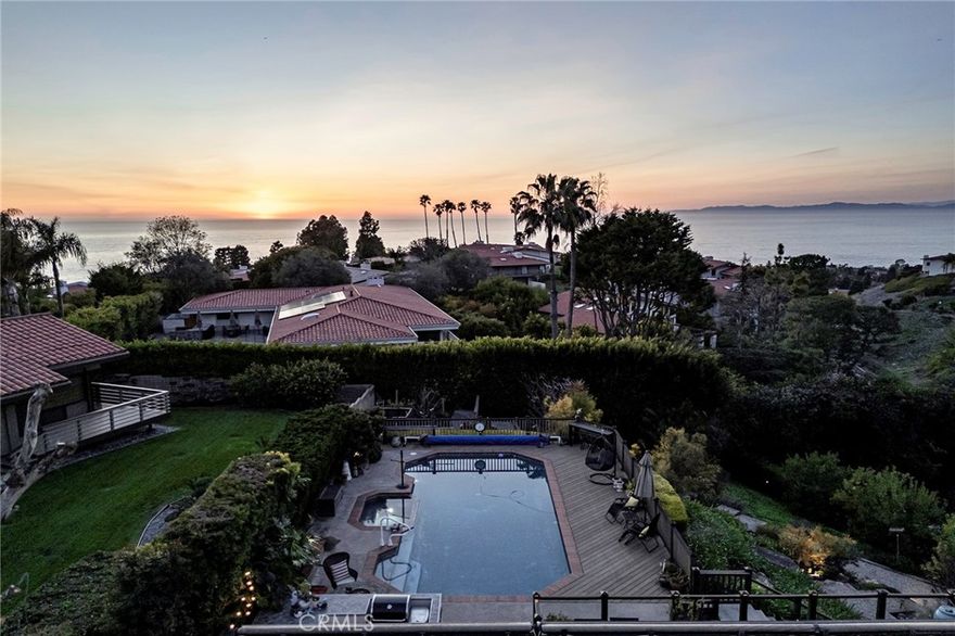 Experience the very best of coastal living in this move-in ready home where privacy, peace, and breathtaking views come standard. Nestled above the ocean, this residence is so private you’ll feel comfortable sleeping with the blinds open to star-filled skies and vibrant sunsets. Step through the grand double doors into an expansive, light-filled open floor plan that blends elegance with ease of everyday living. Walls of glass invite the ocean and hillside views into nearly every room, while the wraparound deck with built-in outdoor kitchen and retractable, lighted awning is perfect for entertaining day or night. The main level is designed for effortless single-level living. The oversized primary suite boasts its own balcony access, dual walk-in closets, and spa-like bath with freestanding tub and dual vanities. Just steps away from the main living area the heated pool and spa extend directly from the heart of the home—your own serene sanctuary for lounging, swimming, or starlit soaks. Downstairs, guests are treated to comfort and privacy with a second en-suite bedroom plus two additional spacious bedrooms that share a Jack & Jill bath. Bonus rooms offer endless flexibility for an office, yoga studio, or playroom. This home truly embraces both grand entertaining and quiet relaxation—from hosting fifty-plus guests in the lush lower garden to cozy family movie nights. The three-car garage, solar panels, EV charger, wine cellar, and fiber optic internet ensure modern convenience meets timeless luxury. Warm wood flooring, custom details, and thoughtfully designed spaces make this a home where you can simply move in, relax, and begin your coastal dream life.