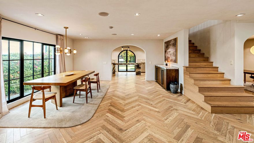 Welcome to this timeless 4-bed, 5-bath Spanish villa, just minutes from Hancock Park. Thoughtfully designed with plastered walls, graceful arches, and light-filled interiors, the home offers a seamless flow: a guest suite downstairs, three en-suite bedrooms upstairs, plus a versatile bonus room. The primary suite is a true retreat with a spa-like bath and oversized walk-in closet, while the chef's kitchen impresses with dual refrigerators, dual dishwashers, and top-tier appliances. Step outside to your private sanctuary complete with pool, spa, built-in BBQ, outdoor shower, fireplace, and TV perfect for effortless year-round entertaining. A fully integrated smart-home system puts everything at your fingertips, blending authentic Spanish charm with modern convenience in one of LA's most coveted locations.