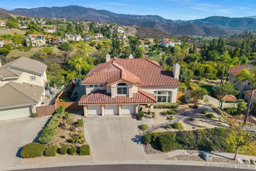 Gorgeous VIEW home in prestigious gated Monarch Ridge! Oversized lot with breathtaking mountain & hill views overlooking a private reserve! Vaulted ceilings, abundant sunlight, and stunning views from every room. Upgrades include: New roof (2023), New deck (2025), Renovated bathrooms (2024-2025). This 5 bedroom/3.5 baths offers a large formal living area and a casual family room with a fireplace. Luxury plank flooring. 1 bedroom and 1 bath downstairs perfect for guests/office. Beautiful kitchen with newer stainless-steel appliances, large island with second sink, and granite countertops. Entertain on your new deck off the gourmet kitchen with retractable awning! Relax under your gazebo with Champagne Grape cascades. Spacious master suite with balcony w/ views, custom walk-in closet, spa-like bathroom with dual sinks, separate shower, and jet tub. Ample space to explore and cultivate your own garden paradise, featuring a variety of fruit trees including fig, lemon, lime, orange, pear, banana, loquats, guava, persimmons, avocado, grapefruit, blackberry, kumquats, mandarin orange, champagne grapes, and passion fruit. Experience the serenity of living in Monarch Ridge, a gated community with beautifully landscaped common areas, dual entrances, and stunning view corridors. Discover approximately 95 acres of open space, complete with walking, hiking, and equestrian trails. Enjoy exclusive access to community amenities such as the pool, spa, cabana, and courts for basketball, pickleball, and tennis. This property is a must-see!