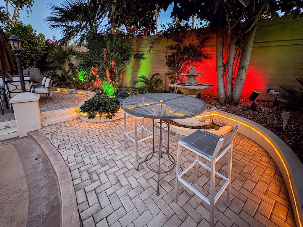Step into a one-of-a-kind luxury RV lot designed for entertaining and relaxation, where vibrant colored accent lighting transforms your evenings into a glowing garden retreat. At the heart of this property is a full-length outdoor kitchen and bar, equipped with stainless steel appliances, including a built-in BBQ, fridge, full oven, cooktop, dishwasher drawer, garbage disposal, and a large sink with hot water. The expansive bar accommodates up to 12, making it the perfect space for hosting friends. Thoughtful features like ample outlets, big storage drawers, and custom covers for all furnishings ensure convenience and durability.Surrounded by lush landscaping and five elegant palm trees, this private lot features multi-level pavers and an elevated dining area with an 8-person dinette. A serene fountain adds a touch of tranquility, while perimeter lighting highlights the space's beauty. The extended lot accommodates a 45-foot RV, a full-size truck, a golf cart, and more, with pool, spa, and laundry facilities just steps away. Furnished and designed for luxury living, this extraordinary lot offers the perfect blend of function, style, and entertainment opportunities.‍