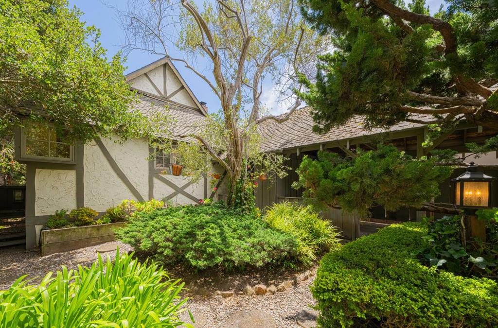 Welcome to this adorable two-bedroom, two-bath Tudor-style cottage, perfectly nestled in the sought-after Carmel Point neighborhood. Situated on an oversized lot encompassing 5,200 sqft and just a short stroll to both Carmel Beach and Carmel River Beach, this cozy yet spacious home combines classic Carmel charm with modern comforts. The bright and airy living room features vaulted ceilings, crisp white walls, and a brick gas-log fireplace flanked by built-in bookshelves. Just up two steps is the dining area and a thoughtfully organized kitchen equipped with an electric range, microwave, dishwasher, and a corner sink. Upstairs, a cozy loft area offers a secondary living space and access to a small private deck, perfect for quiet moments or enjoying the sea breeze. Both bedrooms offer en-suite baths and open to a large deck, which is ideal for morning coffee or evening relaxation. Additional conveniences include a washer/dryer off the kitchen, a single carport plus driveway space, and abundant street parking. Whether you are looking for a weekend getaway, a longer coastal stay, or a successful vacation rental property, this Carmel Point gem offers rentability, comfort, charm, and an unbeatable Carmel Point location.