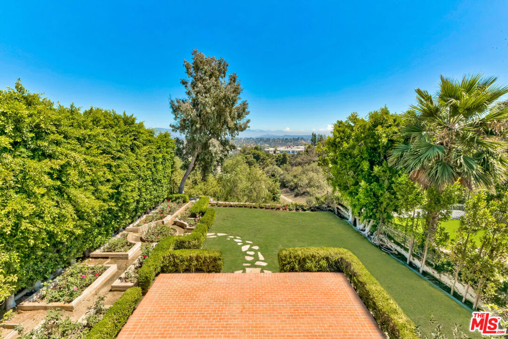 Views, Value, 5,200 sqft of luxurious space, an exceptional backyard, and breathtaking scenic views welcome you to one of the best buys on the Westside! Located in the coveted Mountaingate community of Brentwood, this former model home sits directly along the north golf course of the Mountaingate Country Club. With spectacular fairway and mountain views, and one of the largest, most park-like yards in the neighborhood, it's a great opportunity priced UNDER $700ppsf. The bright, sun-filled interior features remarkable scale & volume, high ceilings, an abundance of windows, crown moldings, exquisite fireplaces, and grand-scaled rooms throughout. You'll love the picturesque backyard with its expansive patios and large grassy areas perfect for pets, putting greens or playgrounds! Have a green thumb for flowers? Enjoy the beautiful mature rose garden designed for year-round beauty. You'll love the flow of the floorplan which offers 4 bedrooms, 4.5 baths, a gracious entry, stunningly large living and dining rooms (with seating for 12-14), a handsome den, butler's pantry, and chef's kitchen with center island and breakfast area. Upstairs, a serene and spacious primary suite boasts breathtaking vistas, big bath and generous closets. Two additional upstairs bedroom suites and a huge upstairs hall (that could be converted into an office retreat). Additionally, there's a downstairs bedroom, guest bath and laundry room. This end unit townhome is wonderfully situated with a large charming front courtyard entrance, an oversized 3-car garage, plenty of guest parking and a hobby room that provides extra flexibility and storage. A blue-chip opportunity to update this into your forever home. Located in the highly acclaimed Roscomare school district, The Crown Villas on Canyonback Road features extensive security measures with 24HR on-site security patrol, HOA alarm monitoring, 24HR camera surveillance, an evening virtual gate system, plus the dues include weekly trash can services, roof coverage, exterior paint maintenance, common area landscaping, and resort-like amenities with lighted tennis courts, beautiful pool, spa, lush grounds and wide, flat, well-lit street for easy pet-walking. Mountaingate in Brentwood is known for its resort-like ambiance and top-notch security, glorious hiking trails embrace you with the majestic Santa Monica Mountains. Optional Memberships to the Mountaingate Country Club with Dining, Golf and Tennis memberships (contact MGCC for membership details). Close to the Westside's finest dining and shopping, UCLA, USC, The Getty Center, LA's famous beaches, and all the great amenities of the sunny California life! *** Please see agent regarding HOA Dues ***