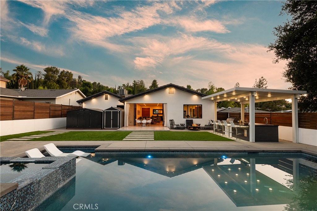 Located on a private, quiet street in one of Woodland Hills most desirable pockets, South of the Boulevard. Thoughtfully expanded and completely rebuilt in 2015, this modern single-story residence features 2,908 square feet of living space, 4 bedrooms and 4 bathrooms. Situated on an expansive, 9,000+ sq ft flat lot on the quiet part of Mulholland giving total privacy with no homes across the street.
A beautiful open concept floor plan featuring high ceilings, porcelain tile floors, and abundant natural light throughout. The custom chef’s kitchen, overlooking the family room, stands out with real wood modern cabinetry, stone countertops, an oversized center island, and sleek stainless steel appliances with floor to ceiling bi-fold doors that create a seamless connection to the backyard. The spacious primary suite includes a walk-in closet, a sleek primary bathroom with dual sinks, custom cabinetry, and walk-in shower.
The standout feature of the property is the massive outdoor entertainment space. Completely private and enclosed with a covered patio, full built-in outdoor kitchen & bar, BBQ, beautiful pool and spa, and grassy play area.
Nature-lovers will appreciate being 15 minutes from Topanga State Park and under 20 minutes to Malibu beaches. Located just minutes from award-winning and highly coveted private and public schools. Close to many fine shops and restaurants, including The Village at Westfield Topanga, and Topanga Mall, Ventura Blvd and the highly anticipated new Rams facility.