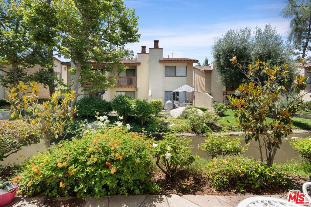 Situated within a well-maintained, resort-style community, this thoughtfully designed 2-bedroom, 1-bathroom townhome offers a rare combination of comfort, style, and natural beauty. Overlooking a serene pond and creek, this residence provides a serene living experience just moments from the dynamic amenities of Warner Center. Step into a bright and open living space filled with natural light, featuring tile floors and a fireplace that adds warmth and charm. The spacious layout flows effortlessly into the kitchen, where you'll find granite countertops, stainless steel appliances, a large breakfast bar. Each bedroom offers a calm and comfortable atmosphere, enhanced by ample closet space and thoughtful design. The private patio is a true retreat, facing a lush pond oasis. The complex itself feels like a resort, with top-tier amenities including a sparkling pool, tennis court, and a recreational room for gatherings and game nights.
