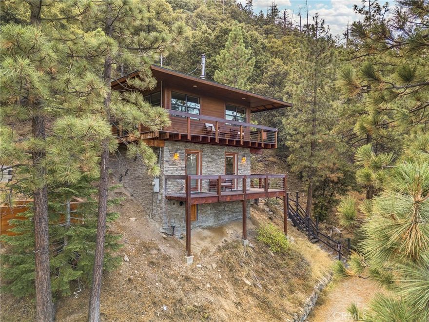 Prepare to be captivated by Zermatt Lookout! Located in the most desirable high-elevation area of PMC, this custom 2004 built home on Zermatt Dr is a true mountain retreat where privacy and stunning views meet. Situated on a peaceful cul-de-sac, this home is inspired by the legendary forestry lookouts of our national parks, featuring a handsome wood and rock exterior, a hipped roofline, and inviting wrap-around decks.



This unique home offers 2 bedrooms and 1 bathroom across its 752 sq ft interior, all designed with custom finishes and boasting breathtaking views from every window. The open-floor plan on the top level features a bright living space, the kitchen (complete with stainless steel appliances and natural wood cabinetry), and a charming wood stove—perfect for those magical winter days.



The property sits on a spacious 24,029 sq ft lot (approx. 0.55 acres), surrounded by majestic Jeffrey and Ponderosa pine trees. Extensive exterior walkways lead up the hillside to the house, an idyllic outdoor seating area, and a relaxing jacuzzi. The lot backs to a green belt and National Forest beyond, ensuring unobstructed northern mountain views and unparalleled seclusion.



For convenience, you're just a short and scenic stroll to Lampkin Park and the charming village center. You'll enjoy easy access to Pine Mountain Club’s exceptional amenities, including a refreshing pool, a challenging golf course, an equestrian center, tennis courts, and a vast network of hiking and biking trails. For those seeking even more adventure, nearby campsites and forest escapes await.



If you appreciate the rustic beauty of a forestry ranger's post, yet desire modern amenities and community access, this home speaks to you. A true one-of-a-kind mountain gem, the Zermatt Lookout is a must-see. Schedule your showing today!