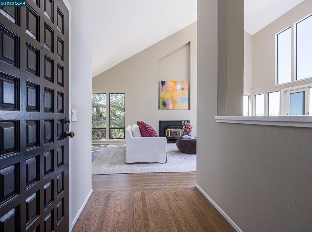 Enjoy San Francisco style in this modern hillside home with contemporary updates, dramatic vaulted ceilings and walls of windows that maximize the impressive 180-degree unobstructed northwest view. Located in the desirable Country Club area of North Orinda, and within a half-mile of the historic Orinda Country Club, and minutes to downtown Orinda, Lafayette and highway 24, are just a few of the reasons this home is so desirable. Towering redwoods and majestic oak trees dot the .81-acre property creating an ultra-private, woodland sanctuary for this approximately 2,614 square foot home that showcases refinished hardwood floors, Andersen dual-pane sliders, and a bright light-filled interior behind a Trex deck entry. Oversized windows and transoms frame the eye-catching views from the sizeable living room, and a sliding glass door offers a seamless flow out onto the spacious view deck. A kitchen updated with quartz counters and backsplash, soft-close cabinetry, a breakfast bar, and GE, Wolf, and Miele appliances also offers an alcove ideal for a reading or relaxing while enjoying the view and access to the deck. A trio of skylights on the vaulted ceiling and more view windows welcome an abundance of natural light into the adjacent dining area; bonus room can also be a 4th bedroom.