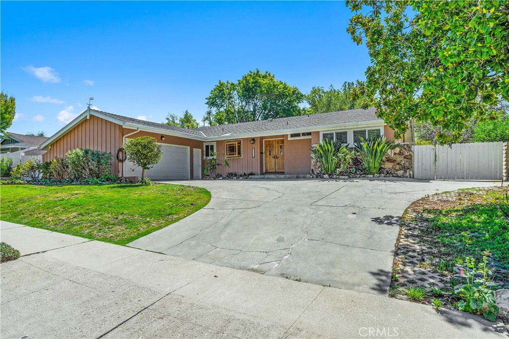 Imagine your own style and design in a prime neighborhood. This one story Heltzer-built home sits on a rare 11,000 SF lot, featuring exceptional potential for expansion, a pool, or an ADU. With extended RV access, a spacious flat backyard, and distant hillside views, the possibilities are endless. The floorplan is enhanced by the vaulted ceilings and original wood floors adding charm, complimented by newer windows and sliding glass doors. The primary suite is thoughtfully positioned away from the other bedrooms for added privacy. A unique third bedroom spans over 20 ft., with a nearby full bath and private patio access that could be perfect for a home office, guest suite or creative studio. The inviting living room centers around a cozy fireplace and opens to the yard through the sliding glass doors. A separate dining area also connects to the outdoors, creating a seamless indoor-outdoor flow. The kitchen is conveniently served by a nearby laundry room with extra storage and direct access to the two car garage. This highly sought after neighborhood is surrounded by top-rated schools and scenic parks, including Lazy J Ranch, Orcutt Ranch, and the Chatsworth Nature Preserve. Nearby shopping and dining options abound at The Village and Westfield Topanga, with medical services at UCLA West Valley Medical Center. Easy access to the 101 and 118 freeways makes for a scenic drive to the city or Malibu beaches. Don't miss this opportunity to reimagine a well-located home with space, privacy and room to design your vision.