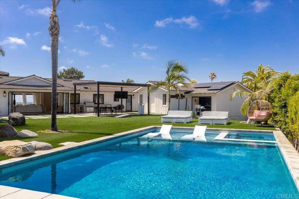 Tucked at the end of a quiet cul-de-sac in one of Coastal Carlsbad’s most desirable neighborhoods, 3170 Falcon Drive is a fully reimagined single-level estate offering effortless luxury, panoramic 180-degree ocean views, and modern design just minutes from the beach. Set on over half an acre, this home features a brand new pool and spa, expansive outdoor entertaining areas, and sleek, high-end finishes throughout. Inside, soaring vaulted ceilings and an open-concept layout connect light-filled living spaces with a designer kitchen anchored by custom cabinetry, a statement island, and a butler’s pantry for added convenience. Thoughtfully designed for modern living, the home includes an expansive laundry room, a stylish mud room, and new black metal-cased windows and doors that frame the stunning ocean vistas and enhance the seamless indoor-outdoor lifestyle. Each bathroom is a showpiece, with high-end materials and custom finishes that elevate every space. As a bonus, approved plans are in place for the completion of an ADU on an existing detached structure, offering flexibility for guests, extended family, or additional income potential. This is coastal living at its finest.