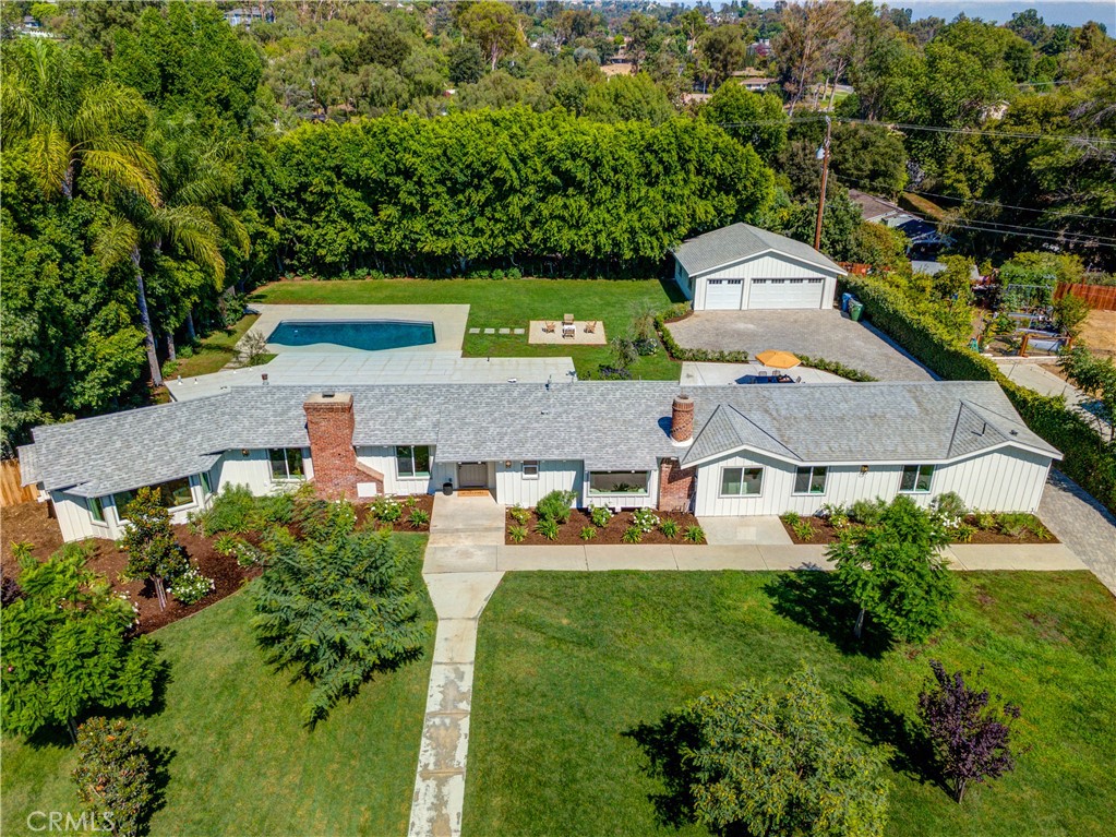 Welcome to this stunning single-level custom ranch-style estate in beautiful Friendly Hills. Situated on a sprawling 27,992 sq. ft. flat, private, and gated lot, this turnkey residence offers timeless charm blended with modern luxury. The home features 4 spacious bedrooms, 3 elegantly designed bathrooms, and approximately 2,710 sq. ft. of fully remodeled living space. A brand-new detached 750 sq. ft. 3-car garage sits behind a private gated entry and paver driveway—an ideal space for a car collection, toys, a future ADU, man cave, game room, or pool house. Step inside and you’re welcomed into the formal living and dining room, showcasing classic wainscoting, a stone fireplace, and built-in shelving, while oversized windows bathe the home in natural light, creating a bright, inviting atmosphere for entertaining or everyday living. The chef’s kitchen is a true showstopper with new stainless steel appliances, farmhouse sink, custom cabinetry, stone accents, and open shelving, and down the hall a large step-down family room with vaulted ceilings offers the perfect gathering space, seamlessly connecting to the dining area with a wall of glass framing the backyard and pool for effortless indoor-outdoor living. Each bathroom has been reimagined with a spa-like feel, including frameless glass showers with designer tile, dual vanities with quartz counters, and brushed gold fixtures, while a freestanding soaking tub beneath a sparkling chandelier creates the ultimate retreat. The primary suite is private and luxurious, while the 4th bedroom with attached bath makes an ideal guest suite or in-law quarters. The backyard is designed for entertaining and relaxation with a resurfaced pool surrounded by mature trees for privacy and a resort-like setting, complemented by a gravel lounge, café-style patio, and expansive lawns that provide space for gatherings, play, and pets. This estate is truly rare, every inch thoughtfully upgraded for both style and function, and just moments from Friendly Hills Country Club with easy access to both Orange County and Los Angeles, the property combines serenity with convenience. Enjoy scenic hills, hiking trails, and Whittier’s charming shops and dining nearby, truly a gem in the heart of Friendly Hills.