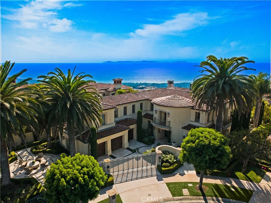Perched at the top of guard-gated Pelican Crest on a premier wraparound lot, this custom coastal estate delivers unobstructed panoramas of the Pacific, Catalina, Newport Harbor, and white-water—sunrises and sunsets alike. Designed for modern indoor/outdoor living, the ~5,268 SF residence offers 4 ensuite bedrooms + office/optional 5th bedroom, soaring volumes, marble finishes, custom lighting, and floorplan that flows from the family room with wet bar to the chef’s kitchen and view terraces. The gourmet kitchen is anchored by Calacatta Gold marble, walnut cabinetry, a La Cornue French range with custom hood, twin glass-door Sub-Zero refrigerators, a walk-in wet bar, and a built-in Miele coffee system—crafted for effortless entertaining. Bi-fold doors dissolve the boundary to the outdoors where a private pool & spa frame the coastline. A serene ocean-oriented primary retreat features a sitting area with custom fireplace mantle, dual boutique-scale closets, and a hotel-inspired bath highlighted by a stand-alone tub. Two main-level bedroom suites enhance livability for multi-generational needs or VIP guests. Outdoors, layered terraces, fire features, and lush landscaping create a private resort setting; inside, multiple fireplaces, an open floor plan, dedicated laundry, and 3-car parking complete the offering. The community has security & guard services and is just moments from Pelican Hill Resort & Golf, Crystal Cove beaches, and Fashion Island dining/shopping.