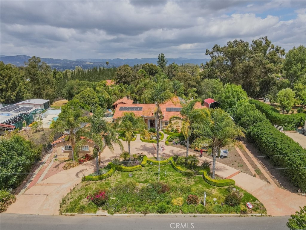 Experience luxury and tranquility with this extraordinary Simi Valley estate. Set on a 43,560 sqft lot, this 4-bedroom, 4.5-bathroom home offers 4,450 sqft of living space, seamlessly blending elegance and modern comfort. Built in 2006, the main house features a grand entryway, spacious living areas, and a chef’s kitchen with a Sub-Zero fridge, double oven, garbage compactor, dishwasher (updated in 2018), and a bay window overlooking the heated saltwater pebble pool and spa, remodeled in 2017. A breakfast nook with additional bay windows offers serene views.
The primary suite boasts a cathedral ceiling, spa-like bathroom with soaking tub, double vanities, walk-in shower, and double-sided fireplace, along with an oversized walk-in closet. Ballroom-style flooring, a waterfall chandelier, and French doors leading to the pool complete the living area. Window shutters and high-speed internet with Eero extenders enhance functionality.
Additional living spaces include a remodeled in-law suite with two bedrooms, two bathrooms, a full kitchen, and laundry, a 2017 guesthouse with a kitchenette and stylish bathroom, and a detached office/game room with an electric fireplace and heater.
The three-level backyard is an entertainer’s dream with a heated saltwater pool, spa, a pond, a covered patio with built-in BBQ, and a Japanese Teppan grill. A stargazing terrace, picnic area, firepit, and water features add charm, while mature fruit trees provide natural beauty. The remodeled three-car garage offers pebble flooring, an EV charging port, and fridge and freezer, while gated RV parking includes two dump stations, water and electrical hookups.
Additional features include 66 fully paid solar panels, a security system with ADT and Ring cameras, and a surround sound system. Please note: Sinaloa Lake membership provides access to exclusive docks, picnic areas, and fishing. This one-of-a-kind estate offers unmatched versatility, privacy, and elegance in Simi Valley.
