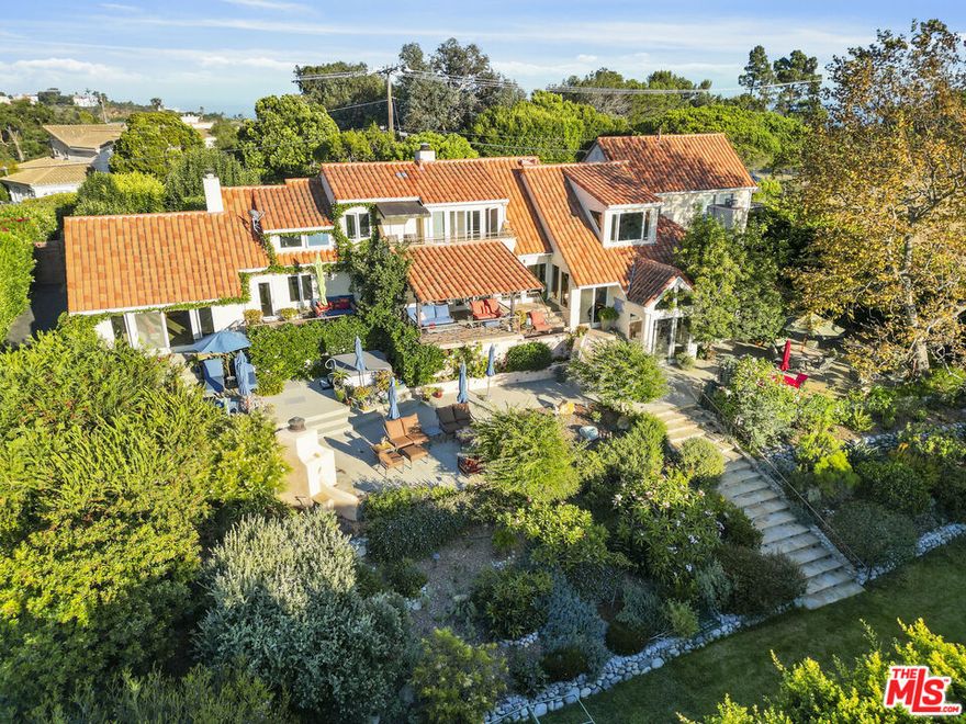 A coastal sanctuary in Zuma Mesa. Perched above the Pacific and set on 1.1 acres with a one-of-a-kind resort-style atmosphere, this estate offers an exceptional blend of elegance, serenity, and California coastal living. Sweeping ocean and canyon views surround the fully walled and gated compound, which includes a 4-bedroom, 3.5-bath main house and a separate, permitted, 1-bedroom, 1-bath guest house, also with ocean views. From the moment you enter the front courtyard, lush, mature landscaping sets the tone for this enchanting retreat. Inside, soaring ceilings and a dramatic sunken living room with a majestic fireplace create a warm yet sophisticated setting, equally suited for intimate gatherings or grand entertaining. The stunning primary suite is a true sanctuary, with a spa-like bath and direct access to the rear patio and gardens, complete with fireplace and spa, where ocean breezes greet you each morning. The cooks' kitchen features a new Miele cooktop, new Bosch dishwasher and center island which opens to a breakfast area and family room, also with a fireplace and access to a covered outdoor dining room. In addition to the guest bedrooms, a loft upstairs offers the perfect space for a home office or gym. Outdoors, the amenities and possibilities are endless: relax in the spa, tend to vibrant gardens, play on the tennis/sport court, sit by the outdoor fireplace, or envision a sparkling pool in the expansive flat grassy yard. Meandering pathways, hidden patios, and colorful landscaping create a rare sense of seclusion in Malibu. The property also includes a three-car garage, currently used as living quarters, along with a state-of-the-art fire suppression system and private water storage. Located in Malibu's desirable gated Zuma Mesa community, this residence is only minutes from pristine beaches, top-rated schools, and Malibu's finest shops and dining. Surrounded by hundreds of acres of the Santa Monica Mountains National Recreation Area with access to miles of hiking and equestrian activities. Convenient community gated entries to both Pacific Coast Highway and Kanan Dume Road ensure effortless connectivity while preserving the tranquility of this hidden gem. Experience the ultimate Malibu lifestyle, where privacy, beauty, and sophistication meet on the endless horizon.