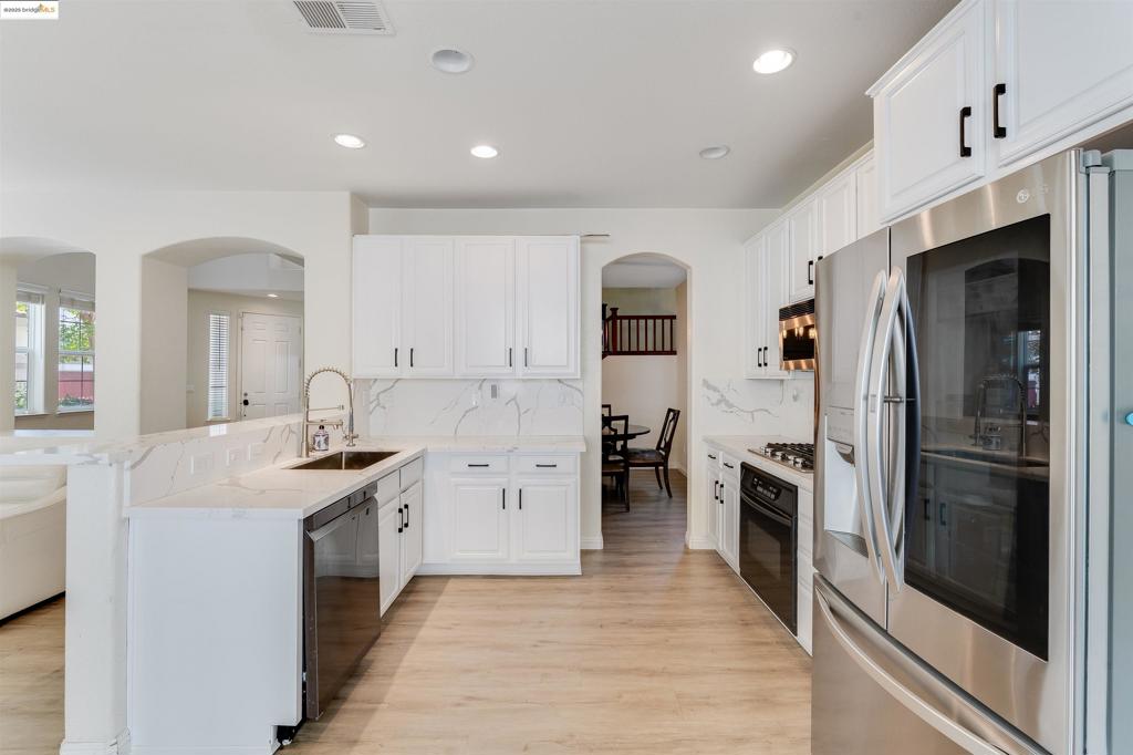 Located in the highly sought-after Siena at Green Valley community, this beautifully maintained home is tucked away on a quiet cul-de-sac and offers the perfect blend of space, functionality, and modern design. Featuring 4 bedrooms and 2.5 bathrooms across 2008 sq ft, the open-concept layout is ideal for both everyday living and entertaining. The updated kitchen features a stylish peninsula layout with quartz countertops, stainless steel appliances, and ample cabinetry, opening to a spacious family room with a cozy fireplace. The home is filled with architectural charm, including elegant archways and arched windows that allow natural light to pour in and accentuate the high ceilings. Upstairs, the spacious primary suite offers a walk-in closet and spa-inspired bath with dual vanities, soaking tub, and separate shower. Venture outside to a private backyard complete with an outdoor bar, no rear neighbors, and a connection ready for a hot tub—perfect for unwinding or hosting guests. Additional highlights include an EV charger and epoxy-coated garage flooring. Enjoy access to nearby walking trails, schools, parks, shopping, and freeway access—this home truly has it all!