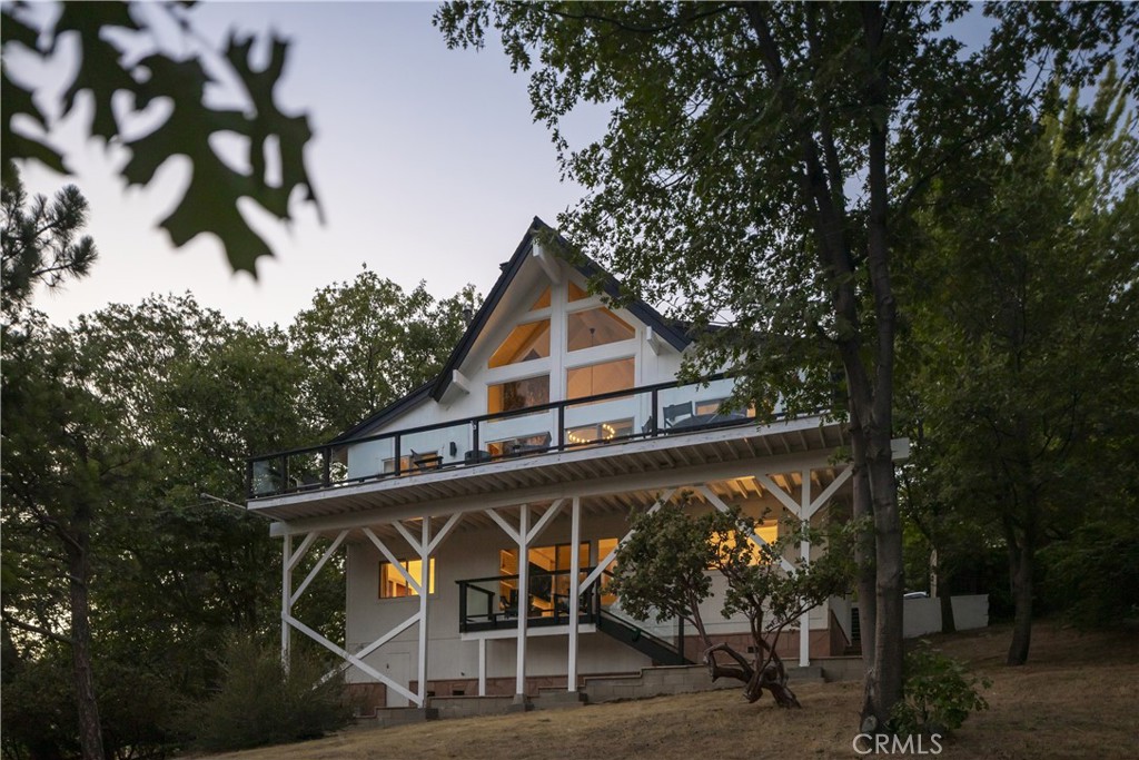 Welcome to Lake + Pine
Tucked just off Lake Arrowhead’s coveted West Shore, Lake + Pine brings light, warmth, and lake views together in all the right ways. With level entry and a fully remodeled interior, this prow front cabin features cathedral ceilings, a statement stone fireplace, and a wall of glass that fills the space with natural light and frames the outdoors.
The main level was designed to entertain, with open living, dining, and kitchen spaces that flow out to a large deck perfect for lounging, grilling, or cozy nights by the outdoor fireplace. Thoughtfully updated with custom tile and newer appliances, the kitchen blends clean design with everyday function. Also on this level is a spacious guest bedroom with its own deck access and a full bath. Downstairs, the second living area features a fireplace, custom built-ins, and a cozy kids nook tucked under the stairs, perfect for games, movies, or a little quiet time. Two more bedrooms, a second full bath, and a laundry room with extra storage complete the lower level. Set on a quiet street just a short walk to the lake and a 10 minute drive to the Village, this is the ideal location to feel tucked away while still being close to everything Lake Arrowhead has to offer. Central AC and a backup generator add to the ease and comfort of mountain living. Currently operating as a successful short-term rental with an active permit in place, Lake + Pine offers flexibility, whether you're looking for a weekend getaway, investment property, or full time retreat, it’s ready to go.