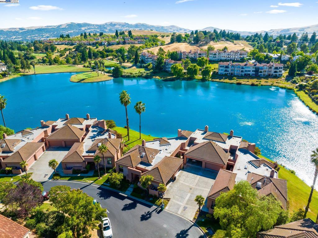 Stunning lakefront townhome at the prestigious Canyon Lakes. Primary suite on the main level provides a private sanctuary with wood and tile flooring, a walk-in closet, jet tub, and dual vanities. The main floor and living room feature soaring ceilings, multiple skylights, a cozy fireplace, and gorgeous views of the lake. Updated gourmet kitchen with stainless steel appliances, built-in oven/microwave, and 5-burner gas cooktop. Enjoy an evening BBQ with a lakeview sunset from the inviting balcony. Downstairs, a versatile family room provides for a peaceful retreat with direct access to the patio and lake, two bedrooms, a full bath, and laundry room with wash basin. Entertain guests with ease and step outside to embrace the true essence of waterfront living. Community amenities include four pools, tennis courts, and a basketball court.