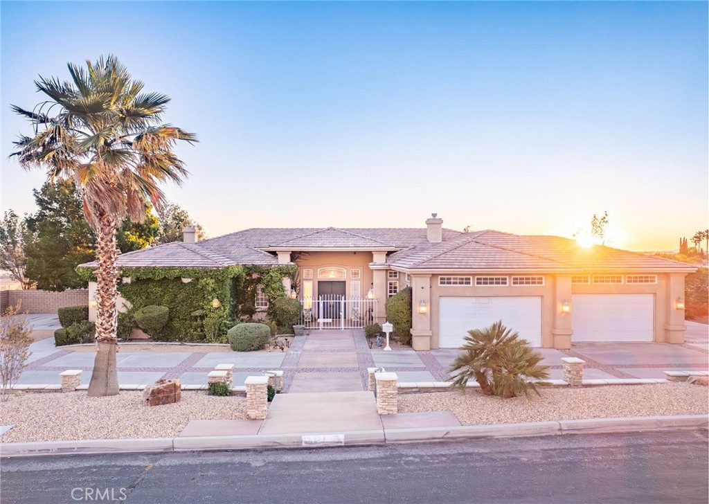 LUXURY LIVING with UNMATCHED VIEWS. Perched on a premium corner lot in one of Apple Valley's most exclusive neighborhoods, this home boasts sweeping views of the mountains and city lights. Enjoy the convenience of being minutes from schools, shopping, restaurants, and churches-while still experiencing peaceful desert living. From the moment you arrive, you’ll fall in love. The mixed concrete circular driveway welcomes you to a gated front courtyard, setting the tone for the elegance inside. Step through the tall double entry doors into a grand foyer where you’re greeted by a Swarovski crystal chandelier, elegant stone and tile flooring, and large windows that flood the space with natural light and frame those incredible views. The open-concept great room is the heart of the home, featuring a cozy gas log fireplace, two stained glass windows, and two striking chandeliers. This space seamlessly combines the living area, dining space, and gourmet kitchen-perfect for entertaining. The chef’s kitchen includes wrap-around granite countertops, a center island with storage, high-end KitchenAid appliances including a 6-burner cooktop stove and convection/standard oven, walk-in pantry, sunny breakfast nook with sliding glass doors to the patio. The oversized laundry room is a standout, offering a shampoo sink and chair, plus ample cabinetry - a rare and luxurious bonus. Accessibility is built into the design, with handicap-equipped bathrooms, including a walk-in shower with an adjustable built-in chair. This home also features TWO BONUS ROOMS, perfect to convert into extra bedrooms, or use as a home office, gym, or hobby space. The master suite is truly a private retreat with separate sitting area, romantic 3-sided fireplace, built-in pot shelves, massive walk-in closet with custom shelving, private slider to the patio. The spa-inspired master bath offers a center walk-in shower, dual vanities with tons of cabinet space, and luxurious finishes throughout. Outside, the backyard is a private oasis featuring a rock-garden courtyard with a tranquil waterfall. The covered patio provides generous space for seating and soaking in the sweeping mountain and city views. 4-CAR GARAGE with many built-in cabinets. RV ACCESS & PARKING. This home is loaded with upscale features too numerous to list. A true must-see for the most discerning buyers. Hurry! Homes like this don’t last long. Schedule your private showing today before it’s gone