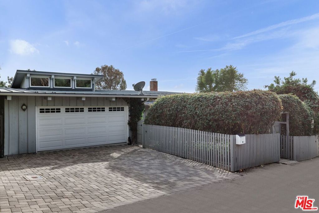 Set in the exclusive guard-gated Serra Retreat neighborhood of Malibu, this ocean-view home offers a rare opportunity to own in one of the area's most coveted enclaves at an exceptional price point. Just moments from the Malibu Pier, Surfrider Beach, Cross Creek shops, and the historic Monastery, the location blends luxury, privacy, and convenience. Inside, the open-concept living and dining rooms feature vaulted ceilings, floor-to-ceiling windows, and a cozy fireplace - all framing sweeping ocean vistas. The sunlit primary suite is a serene escape with a spa-style bath, oversized steam shower, and generous walk-in closet. Two additional bedrooms offer flexibility for guests or office use. Expansive decks are ideal for entertaining or quiet mornings with the sea breeze. Outdoor amenities include a cedar hot tub, cold plunge, outdoor shower, fruit trees, and dual grassy yards. A rare chance to live the Malibu dream with the Pacific Ocean as your daily view.