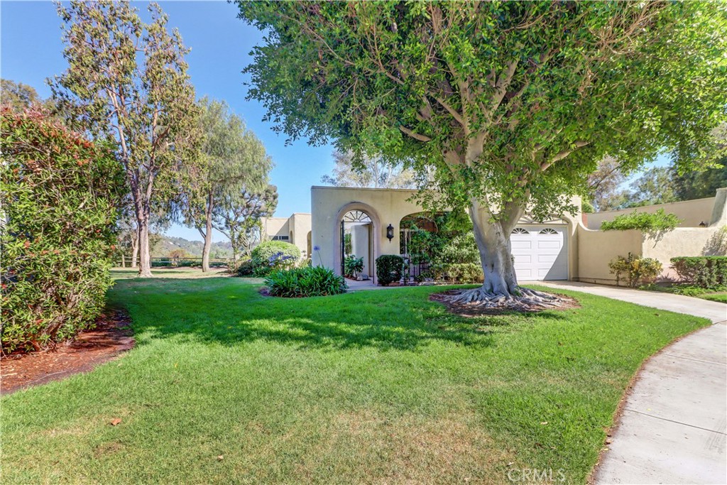 Enjoy the great view from this "Casa Rosa" condo with bluff-top location with sunny south east orientation from the covered patio. Check out the Virtual walk-thru tour where you can walk outside and see the view. End unit condo with beautiful green spaces, mature tree in front yard located at the end of a beautiful winding street enjoying beautiful hill-top vistas! Attached 1 car direct access garage and driveway space. Pretty arched entryway with wrought iron accents provide a welcoming entry. 2 patio areas - smaller one in the front and another larger area in the back with access from living room and both bedrooms. Walk right in and notice the cathedral ceiling in the living room and laminate flooring drawing your eye out to the main attraction - the view!! You'll love the fresh paint, dual pane windows, plantation shutters, custom blinds and central HVAC. Galley-style kitchen features recessed lights, stainless appliances, huge skylight and direct access to the oversized garage with washer/dryer. New water heater is being installed in the garage. Added front room provides a nice space as den/office/extra bedroom/dining area - take your pick! This floorplan has 2 large bedrooms on opposite sides of the living room. One side has a bathroom easily accessible to guests with tub/shower combo and nice-sized walk-in closet. Both bedrooms have laminate flooring and sliding glass doors leading to the patio area. On the opposite side is the true "primary suite" including private bath with walk shower and toilet behind the privacy door. This bedroom does not share an exterior wall and also has sliding door access the patio. This is a mostly original home with awesome location and view - ready to move-in and enjoy as-is or remodel to your own taste. Laguna Woods Village residents enjoy a 27-hole championship golf course, a 9-hole executive par 3 course, pickleball and tennis courts, lawn bowling, gyms, clubhouses, swimming pools, horse stables, gardening centers, artist studios, computer workrooms and classes + over 200 clubs and organizations. CHECK OUT THE MATTERPORT WALK -THRU TOUR. CLICK ON THE CIRCLES TO EXPLORE, 360 ICON TO WALK OUTSIDE AND WALKING PERSON ICON TO COME BACK IN!