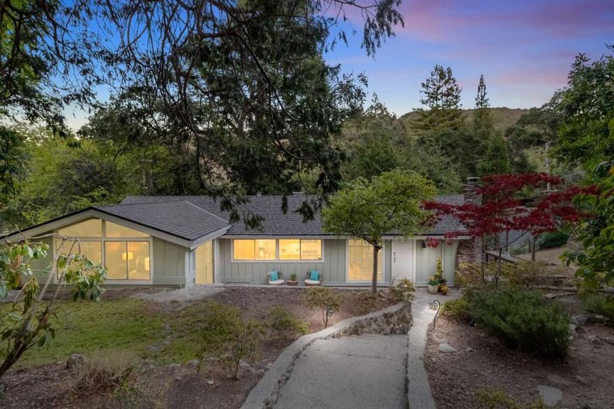 Discover the perfect blend of nature and modern convenience at 1019 Los Trancos Road in the peaceful Los Trancos Woods neighborhood. This charming home, built in 1930, offers 1,770 SF of versatile living space (per the Seller) in two buildings with freshly painted exteriors. The 1,225 SF main house features three bedrooms and two baths, with vaulted ceilings and skylights that invite abundant natural light. The airy living room, featuring exposed beams, seamlessly transitions to a large deck and patio, ideal for indoor-outdoor entertainment. The galley kitchen is a chef's delight, featuring stainless steel appliances and ample cabinetry that overlooks the garden. A 545 SF studio is situated behind the one-car garage. While not reflected in the County records, the studio is a flexible space with a kitchen, stacked washer/dryer, full bathroom, new wall-to-wall carpeting, and a private deck - ideal for multi-generational living, working from home, or generating rental income. Positioned on a generous 9,360 SF parcel, you'll enjoy peaceful views and easy access to Portola Valley's lively Town Center and Highway 280 for easy commuting.
