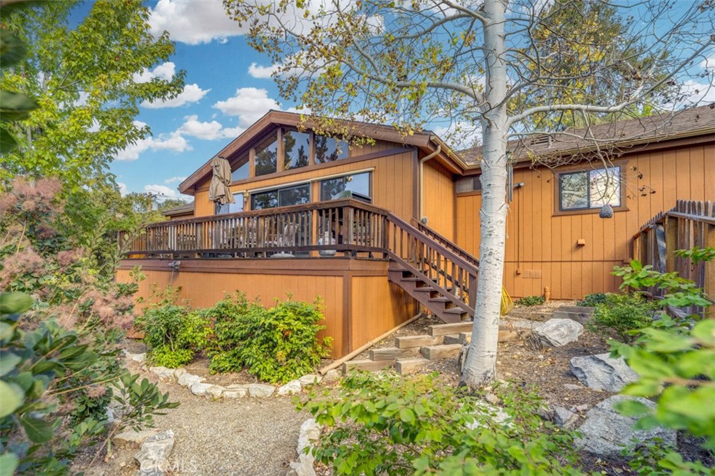 Step into your mountain sanctuary at 15420 Live Oak Way, where rustic charm meets modern comfort in a single-level haven that feels like home the moment you arrive. Nestled on a beautifully landscaped lot with mature trees and a fenced rear yard, this retreat beckons you to embrace the serenity of mountain living, perfect for full-time residence, remote work, or a vacation escape.
Enter through the welcoming foyer into a spacious great room that captures the heart. Soaring wood-beamed ceilings and large windows frame stunning mountain views and vibrant sunsets, while a freshly cleaned wood-burning stove adds cozy warmth. New hardwood flooring (2024) flows throughout, tying the open-concept layout together with timeless elegance. The kitchen, open to the great room, features a large island for casual meals or lively gatherings, ample storage, and modern appliances. The adjacent dining area spills onto a spacious deck, expanding your living space into the crisp mountain air—perfect for morning coffee or evening stargazing.
The split-wing design ensures privacy. The primary bedroom, a tranquil retreat, offers an en-suite bathroom, walk-in closet, and private deck access for quiet moments. Two well-sized bedrooms share a full guest bathroom, and garage access nearby for convenience. The attached garage, plus extra parking in front and on the side, makes hosting effortless.
This home is as practical as it is inviting. A 2022 electrical panel upgrade, new water heater, softener, and filtration system (all 2022) ensure efficiency and peace of mind. A rainproof under-deck storage area adds clever functionality, while central heat and AC keep you comfortable year-round. This home is ready for you to move in and start living your mountain dream.
Imagine working from home with inspiring views, hosting friends on the deck, or unwinding in the serene yard. 15420 Live Oak Way is more than a house—it’s a lifestyle waiting for you to claim. Schedule your private tour today and write the next chapter of this mountain story!