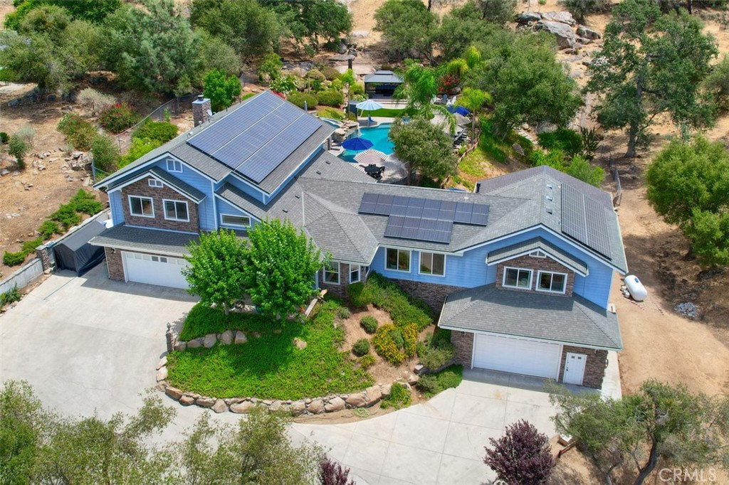 Resort -Style Living in the Sierra Foothills! 4 Bedrooms-3.5 Baths, 4 Car Garage+ Shop, Approx. 4300 Sq. Ft. Whether you're entertaining under the palm trees, this property delivers luxury & tranquility in one unforgettable setting. Welcome to your private Oasis and breathtaking estate offering a sparking pool W/Spa, waterfall, slide, expansive decking, lighting for all those special occasions, lush landscaping that creates a true resort feel. A magical pathway around the lush landscaping. The beautifully updated home features expansive windows, modern amenities, & seamless indoor-outdoor living. With 93 Owned SOLAR Panels- NO PG&E Bills!!! Enjoy energy efficiency without sacrificing comfort. A Kitchen designed to impress & perform, W/Pantry, Dining Room, Breakfast Nook, Living Rm., Family Rm./Game Rm. Sunroom, 2 Fireplaces, a LIFT access to second story if needed, electric ramp in garage as well as pool, storage galore, room for the RV, mature assorted fruit trees and room for your garden. ALL of this just a short, scenic drive to Bass Lake, Yosemite National Park, Oakhurst, Fresno, making it the perfect Mountain Retreat. A Rare Gem Nestled in the Heart of the Sierra Mountain Communities. Also want to mention the amenities of Yosemite Lakes Owners Association, Golf, Parks, Ponds & Lakes, Tennis, Basketball, Baseball Field, Kids Park, Club House, The Bar & Grill for your dining pleasure, Free Library, Summer Music Concerts Free for All Family's. Call your Realtor Today!!!