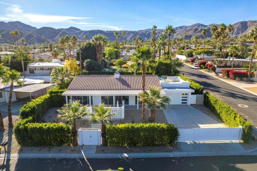 Completely renovated 1950s Mid-Century Modern retreat--designer-curated and move-in ready.Tucked inside a private gated yard, this beautifully reimagined mini-estate blends modern luxury with timeless vintage character, offering stunning mountain panoramas, sparkling city-light views, and resort-style outdoor living.A welcoming courtyard entry sets the tone as you step into an open, spacious floor plan with vaulted ceilings and walls of glass. The home features four generous bedrooms and two elegantly updated baths, including a luxurious primary suite with an oversized walk-in closet and a spa-inspired bath complete with a free-standing soaking tub and rainfall shower.The gourmet kitchen is a showpiece--beautifully remodeled with quartz countertops, designer backsplash, extensive cabinetry, and premium Fisher & Paykel appliances. Oversized floor tile, double-pane windows and doors, stylish lighting, and thoughtful built-ins add to the modern sophistication woven throughout the home.Outside, the property lives like a boutique resort. Enjoy a newer custom pool and spa, shade structure, BBQ area, outdoor shower, lush turf, desert landscaping, and tall privacy hedges that create the perfect oasis. For the ultimate viewpoint, a private rooftop deck offers breathtaking mountain and desert vistas--ideal for sunsets or stargazing.Additional upgrades include newer paint, electrical and lighting systems, a newer AC unit, newer pool equipment and heating system, and an attached 2-car garage with a vehicle charging system.Ideally located--just minutes from downtown Palm Springs, local hiking trails, casinos, shopping, and dining--this exceptional residence is a rare opportunity to enjoy true resort-style living in one of Cathedral City's most desirable areas. A meticulously modernized home that still honors its mid-century roots.